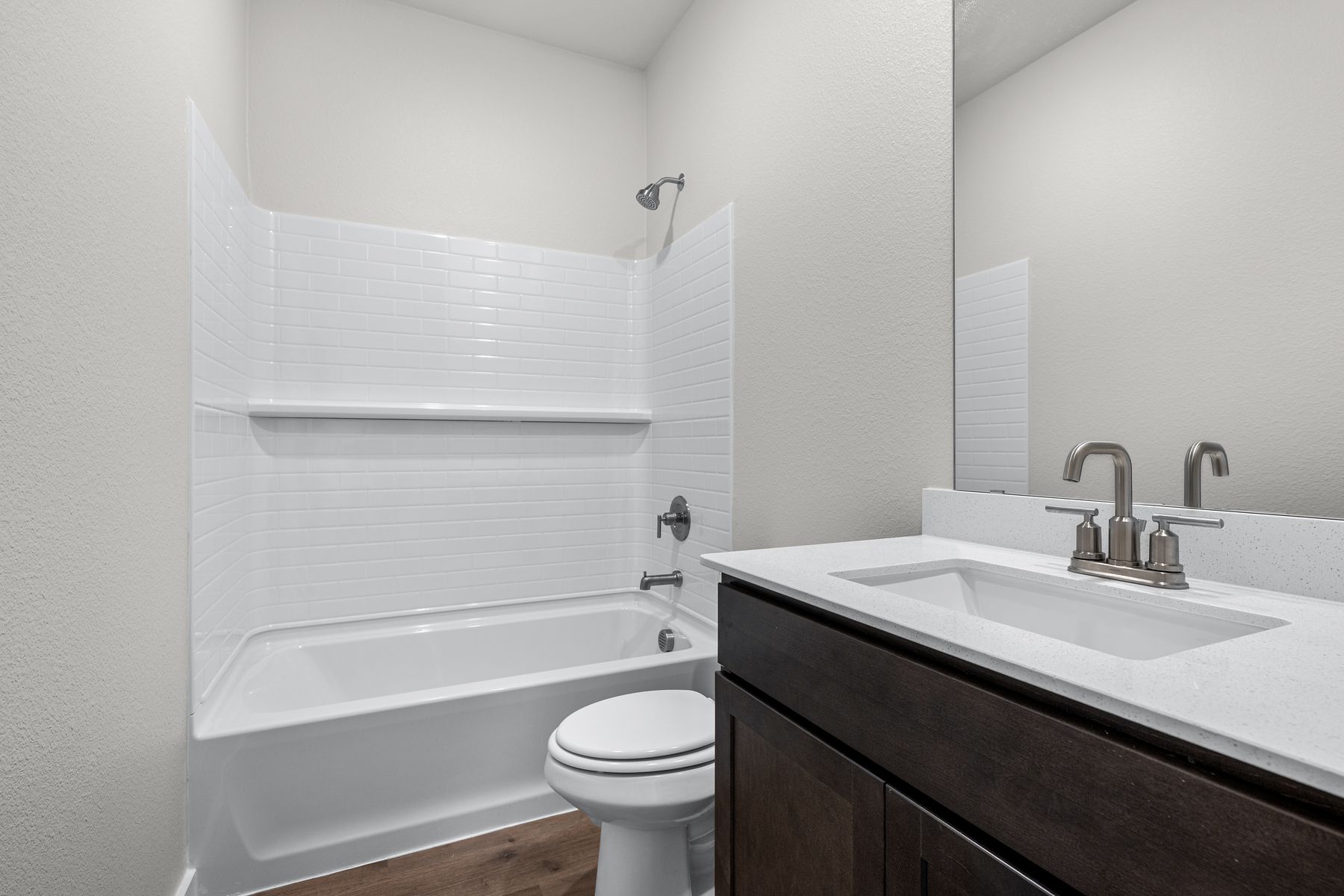 The secondary bathroom has a sprawling vanity space and a shower-tub combo.