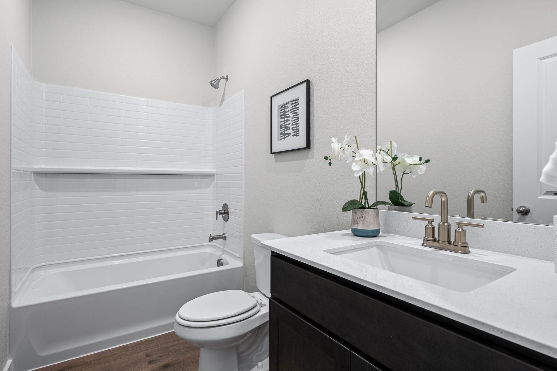 The secondary bathroom has a sprawling vanity space and a shower-tub combo.