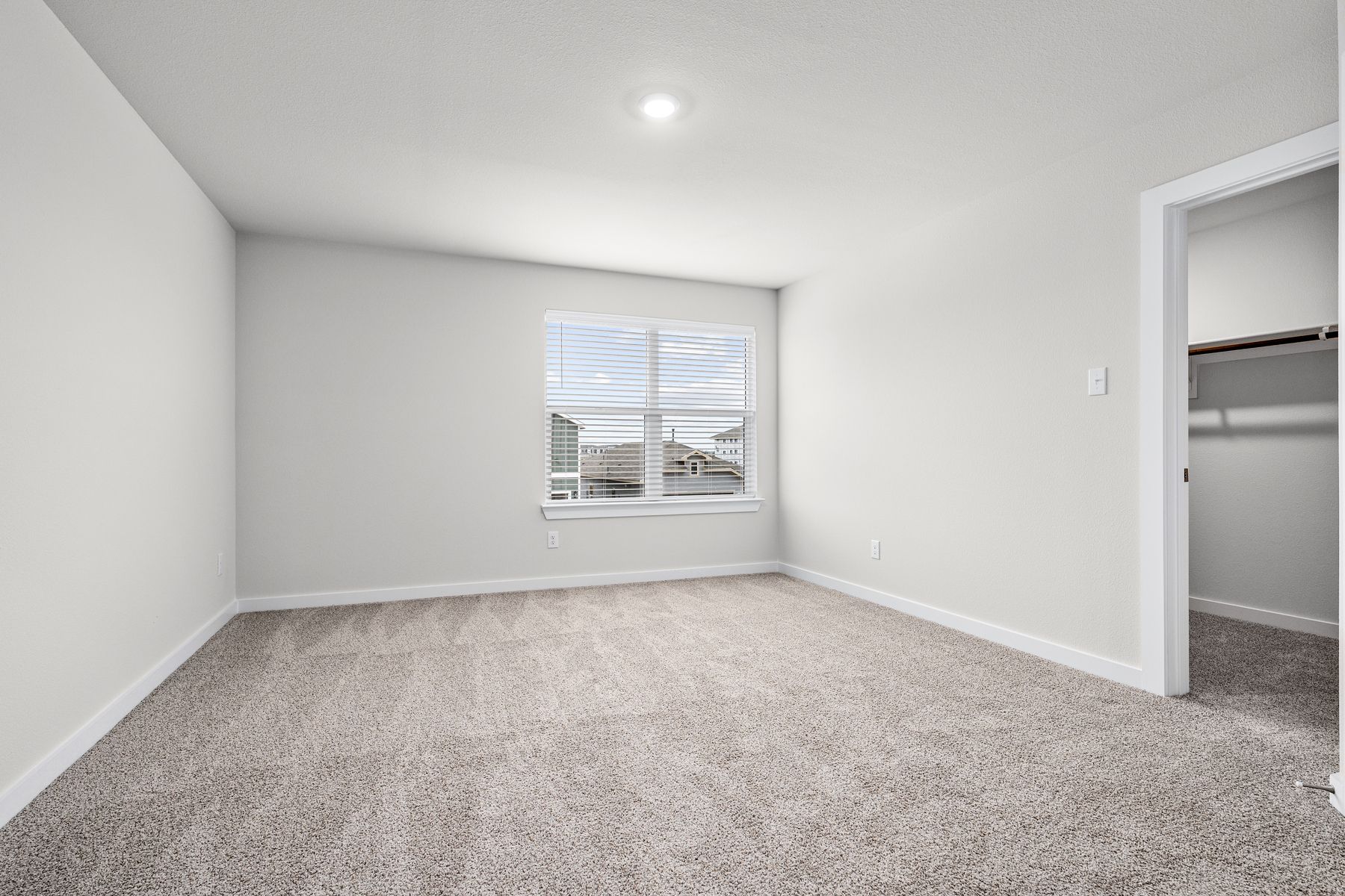 The master bedroom is spacious and has a large window.