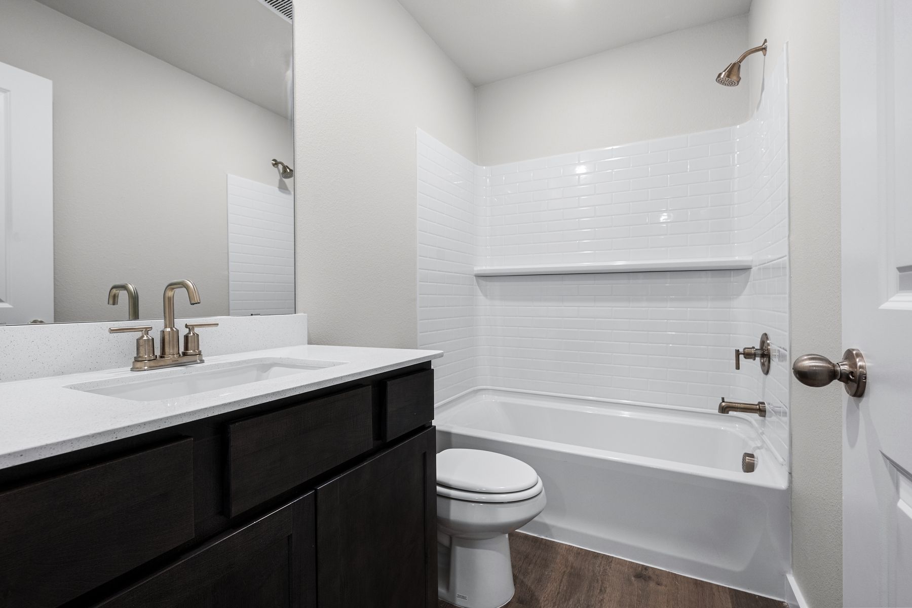 The secondary bathroom has a sprawling vanity space and a shower-tub combo.
