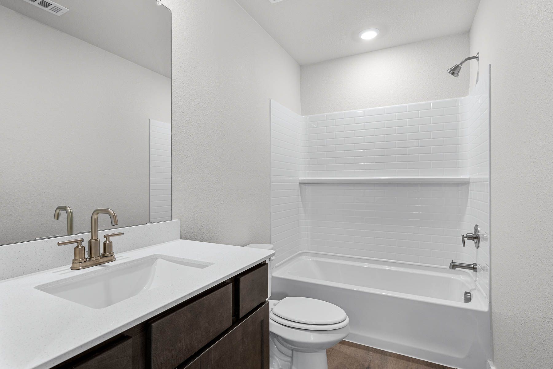 The secondary bathroom has a sprawling vanity space and a shower-tub combo.
