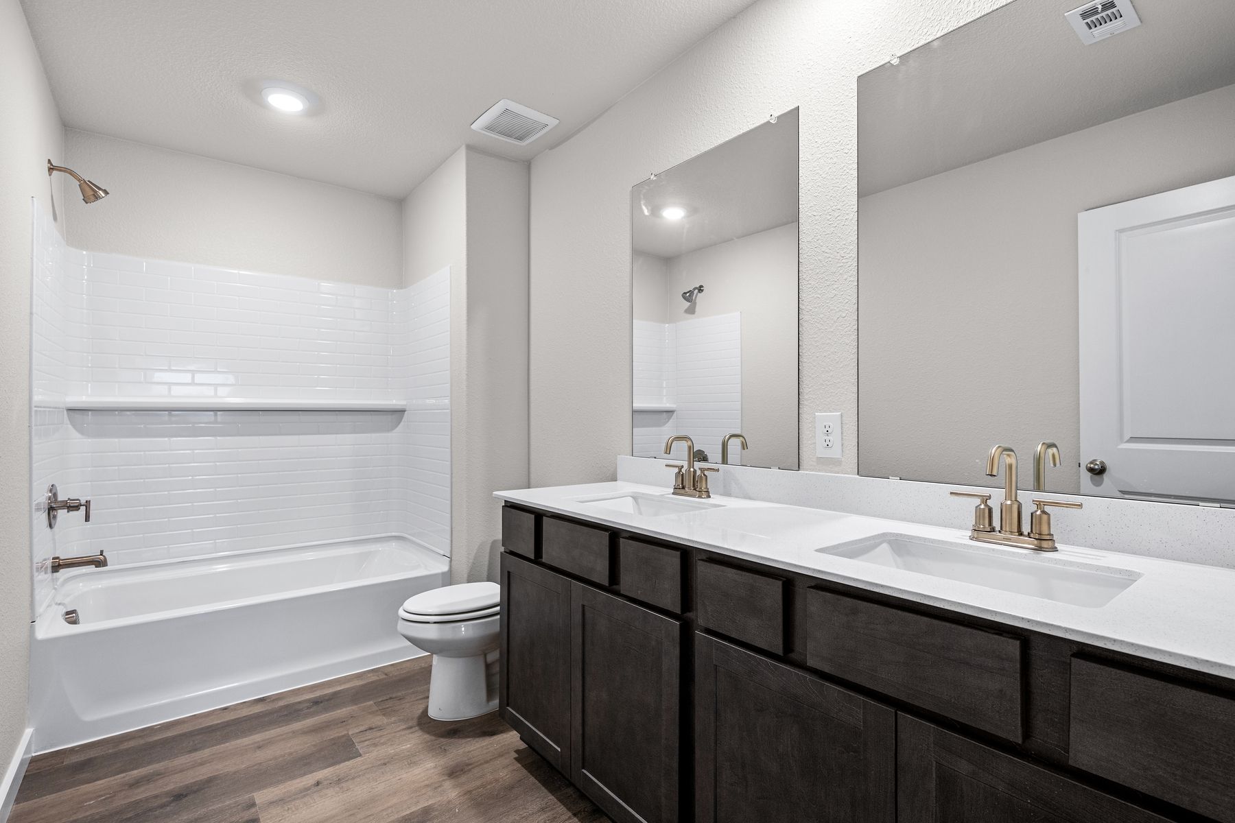 The secondary bathroom has a sprawling vanity space and a shower-tub combo.