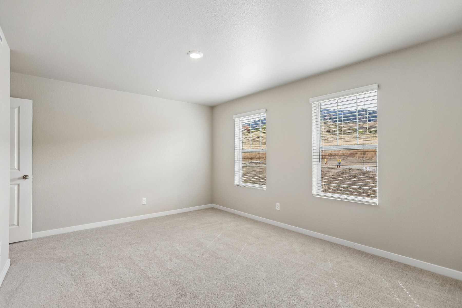 The master bedroom is spacious with large windows.