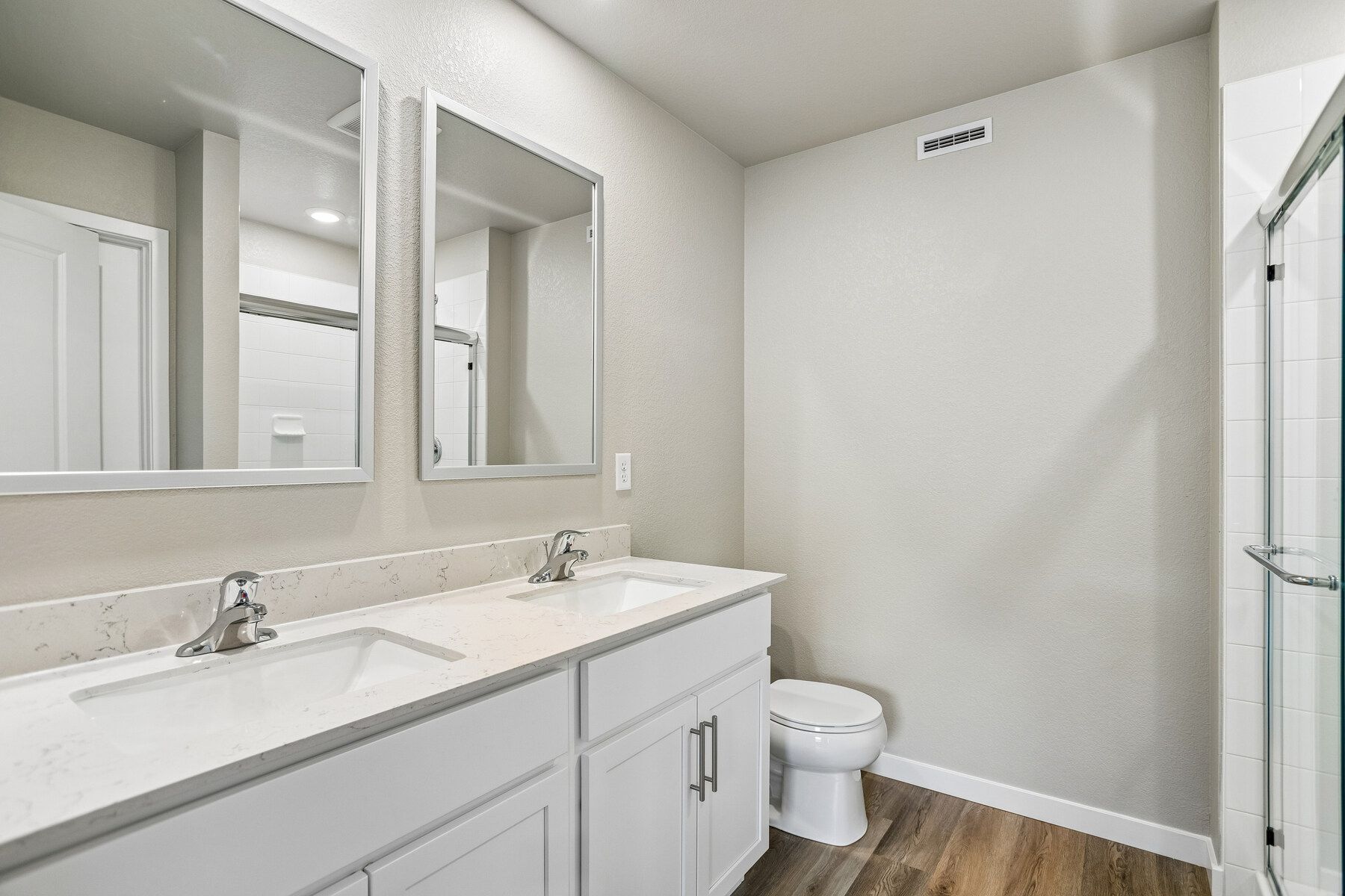 The master bathroom has a large vanity with a step in shower.