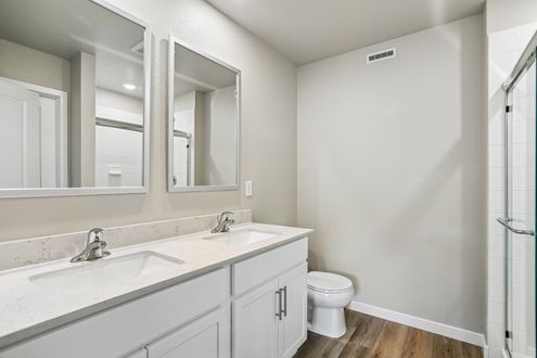 The master bathroom has a large vanity with a step in shower.