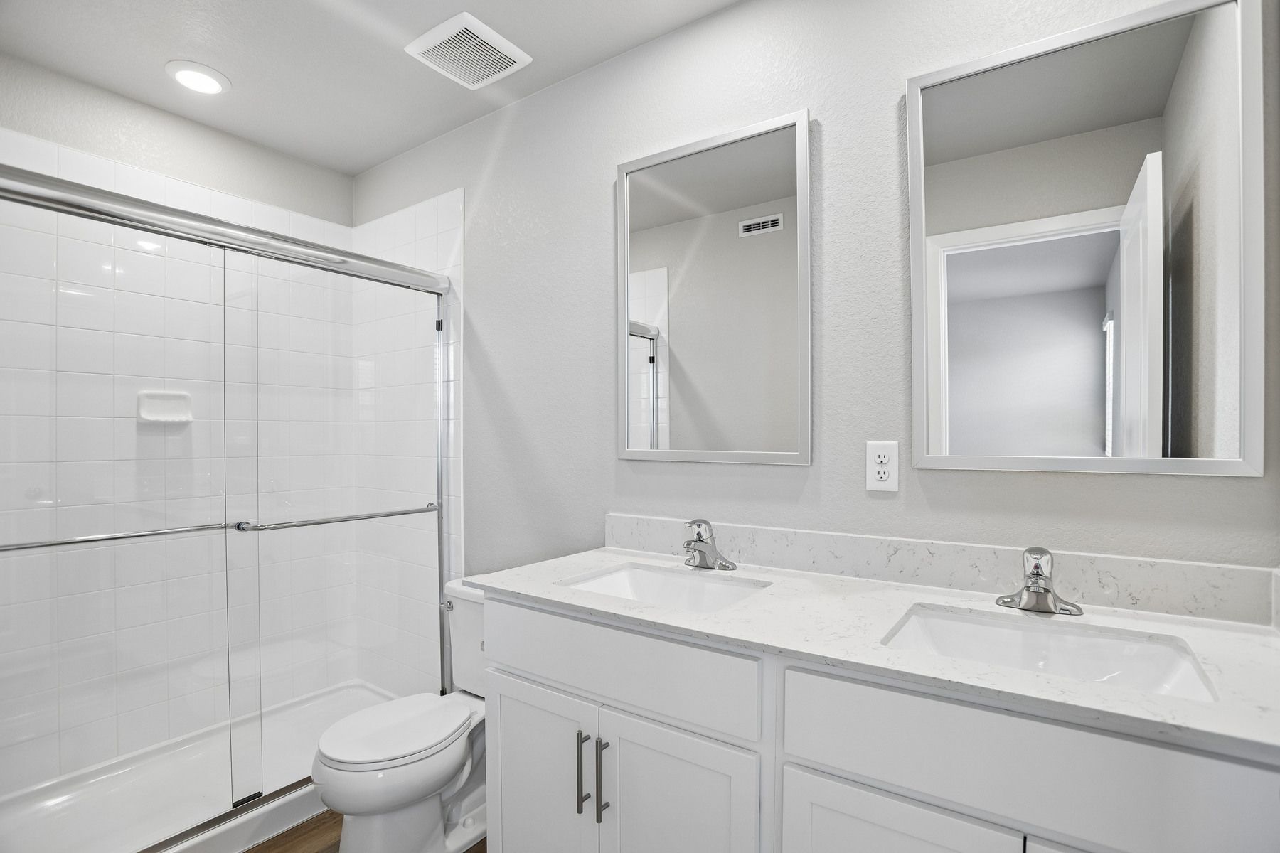 The master bathroom has a large vanity with a step in shower.