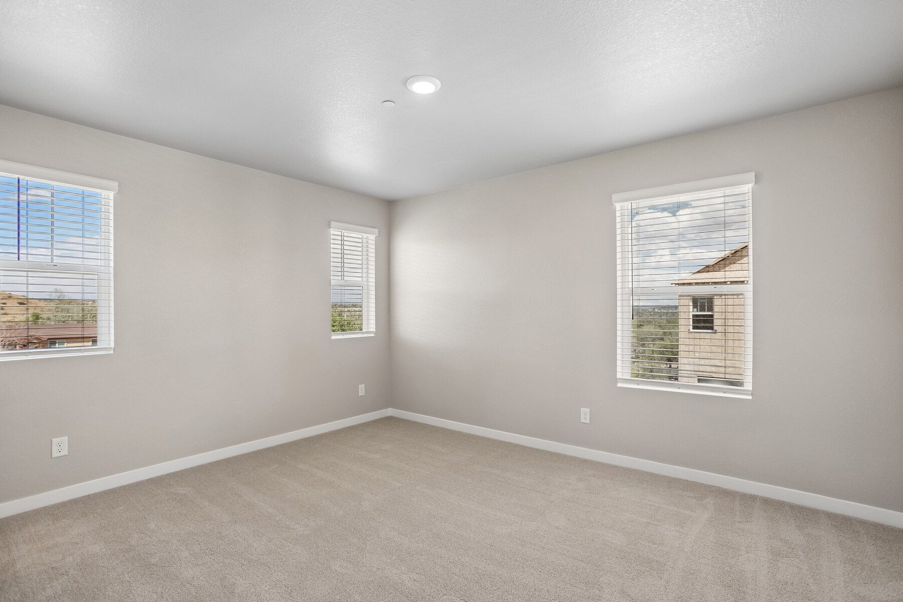 The master bedroom is spacious with windows.