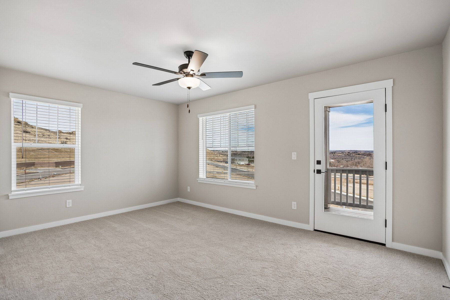 The master bedroom is spacious with a ceiling fan.