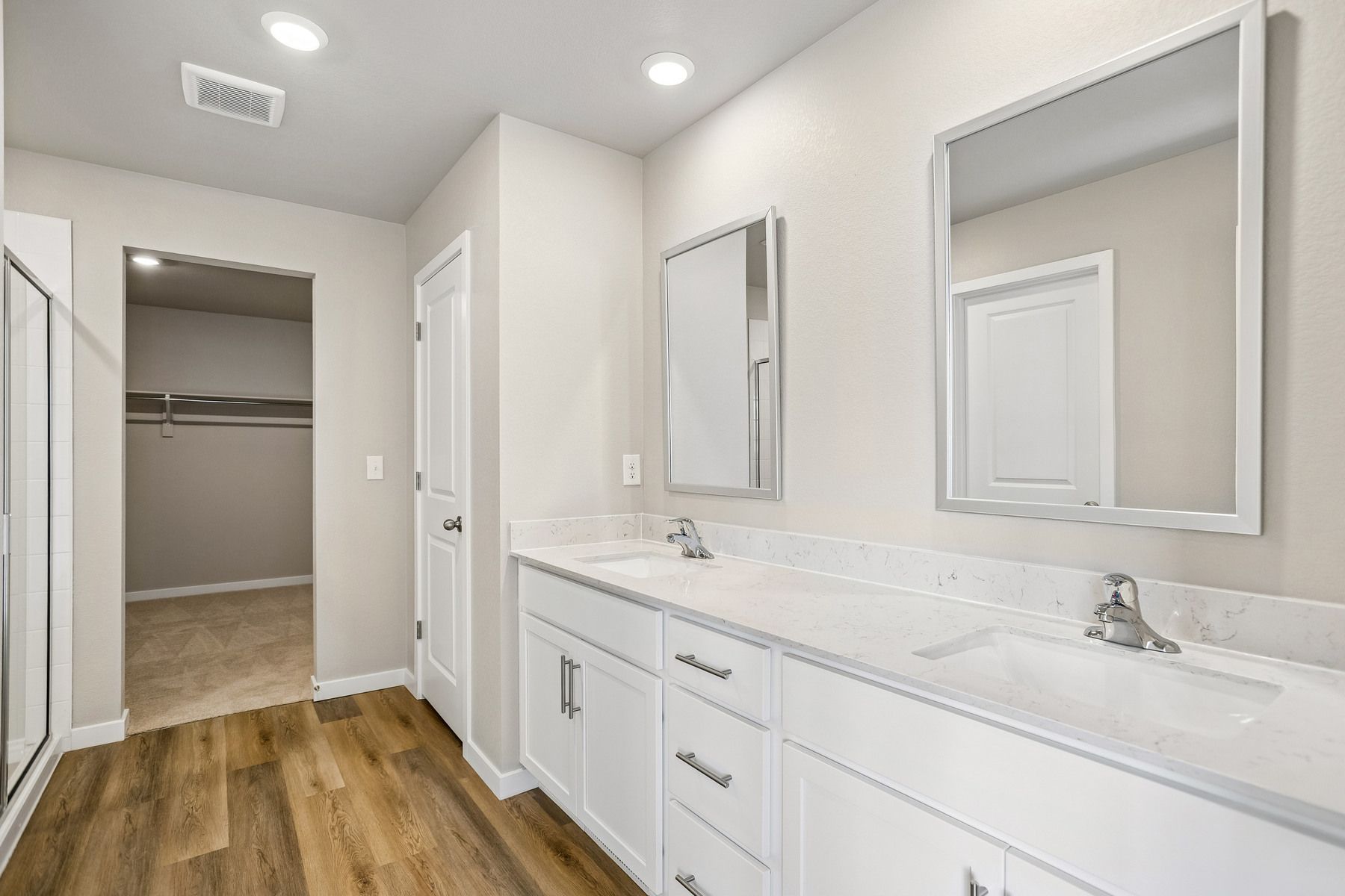 The master bathroom has a large vanity with a step in shower.