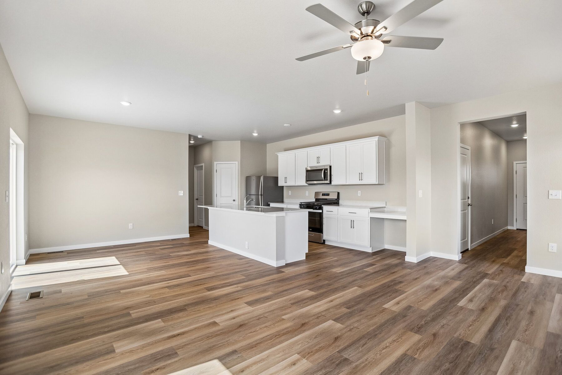 The family room is spacious with a ceiling fan and an electric fireplace.
