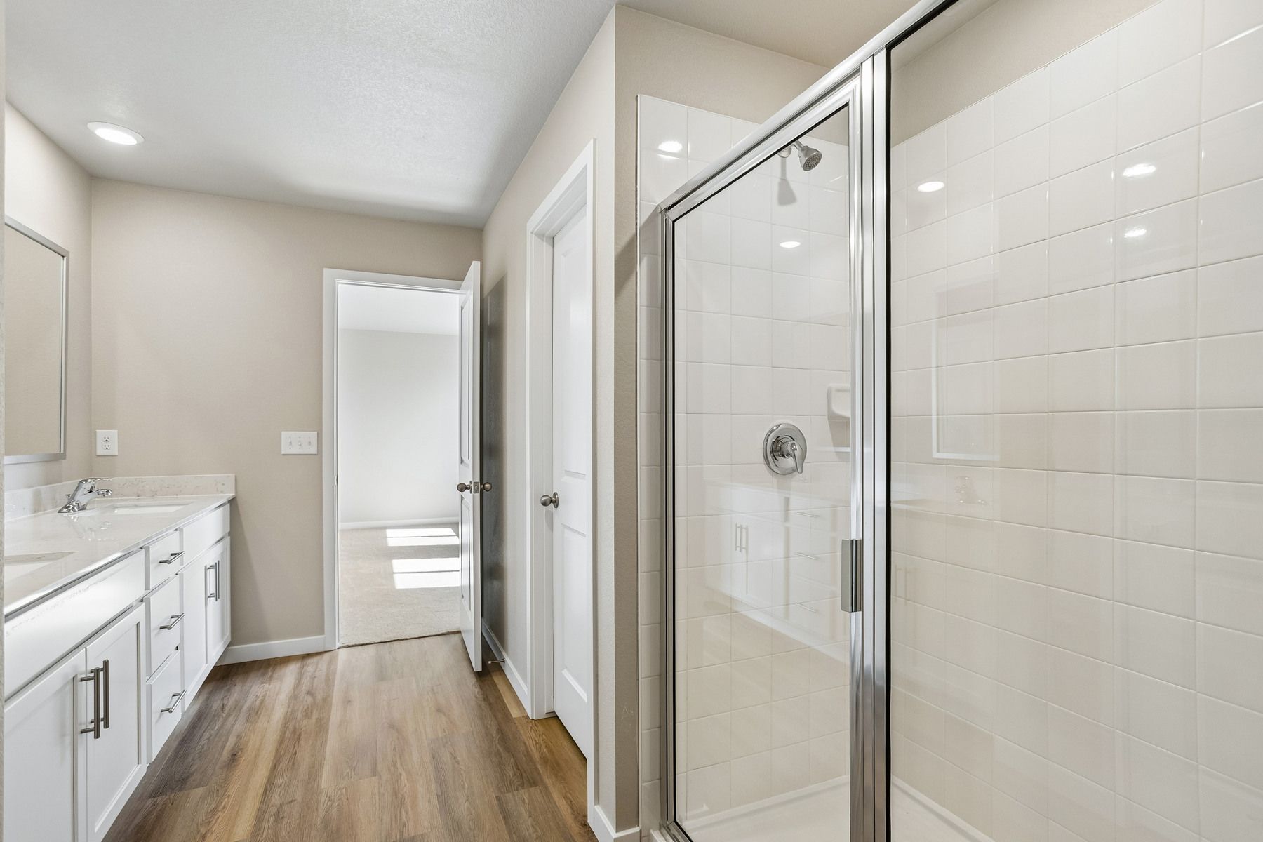 The master bathroom has a large vanity with a step in shower.