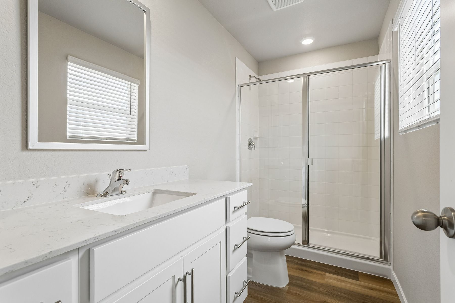 The master bathroom has a large vanity and a step in shower.