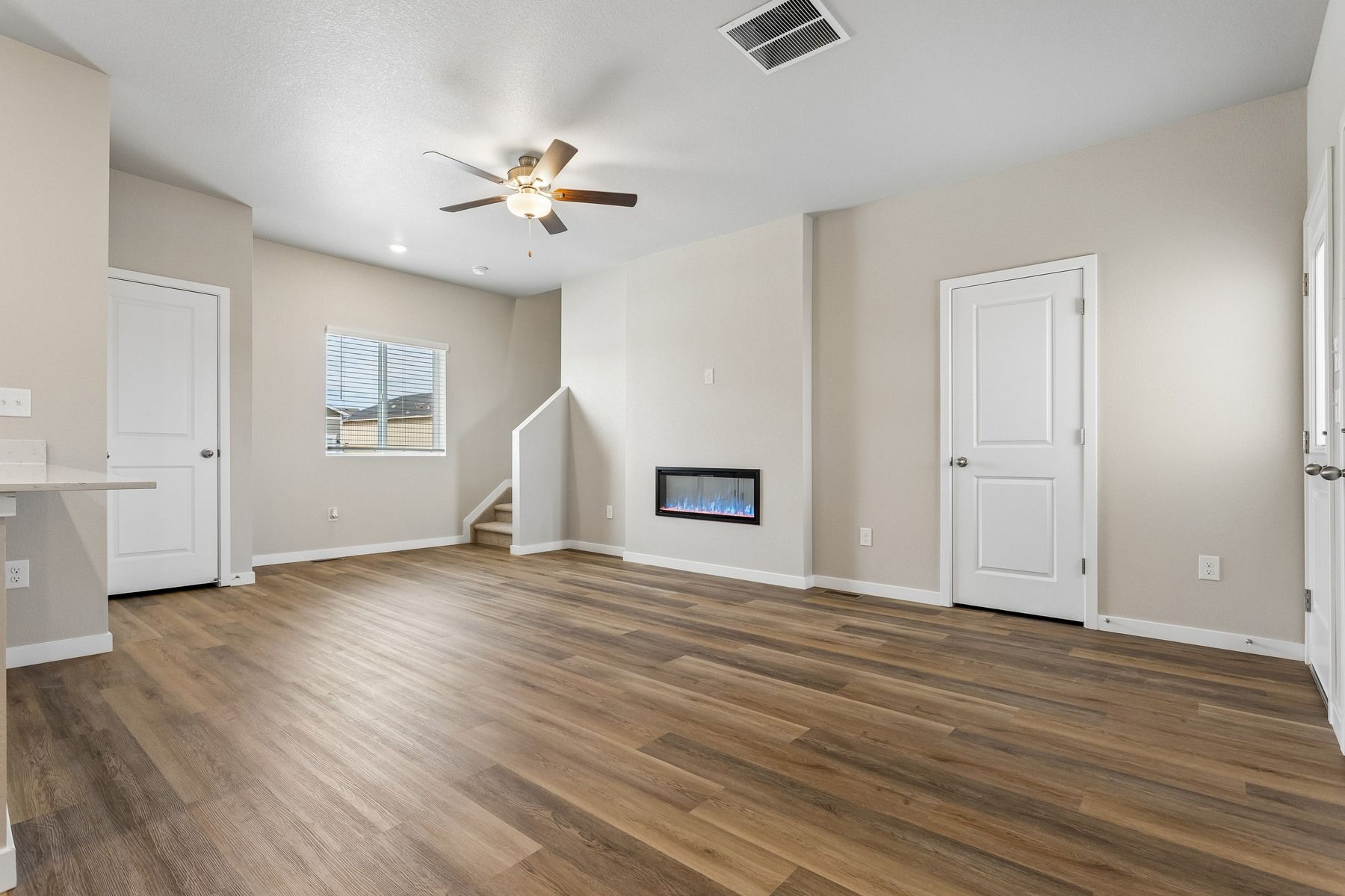 The family room is spacious with a ceiling fan and an electric fireplace.