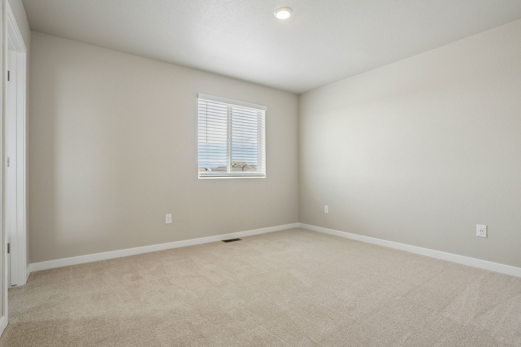 The master bedroom is spacious with a large window.