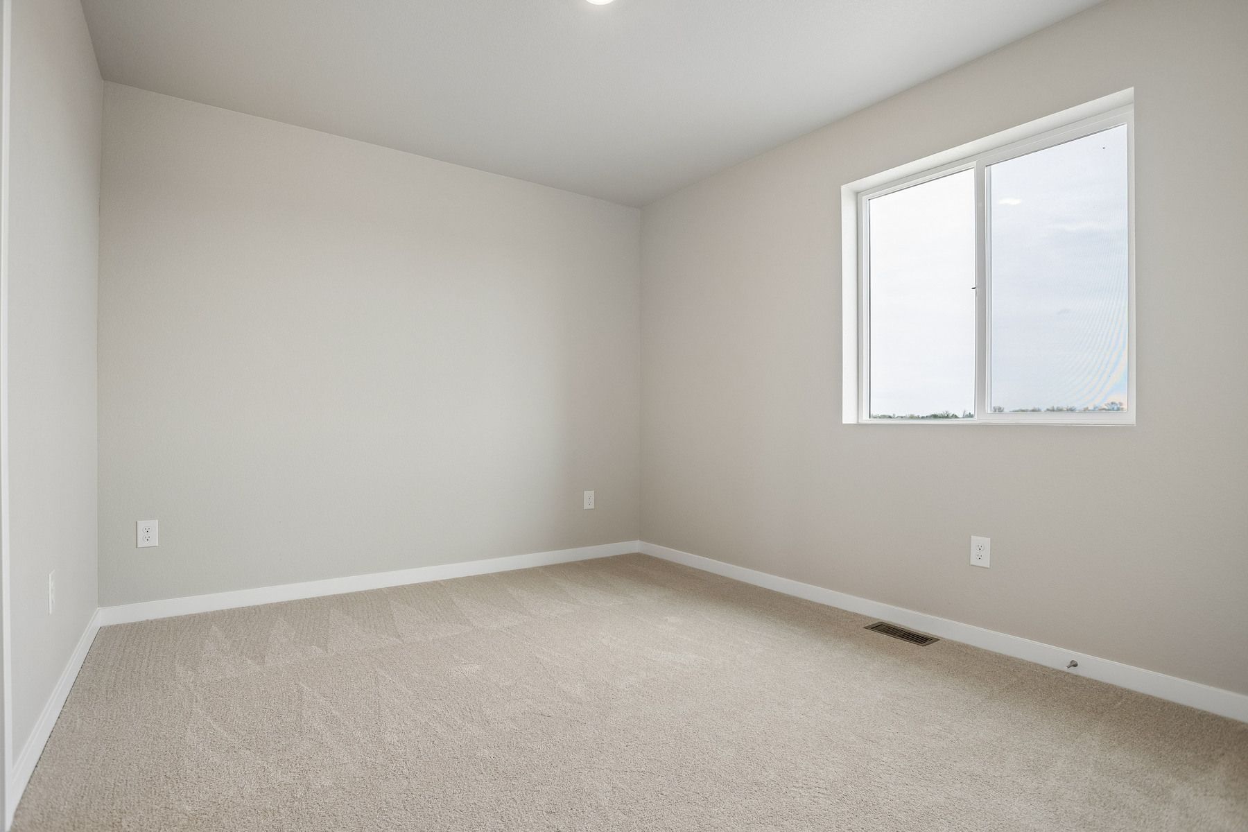 The master bedroom is spacious with a large window.