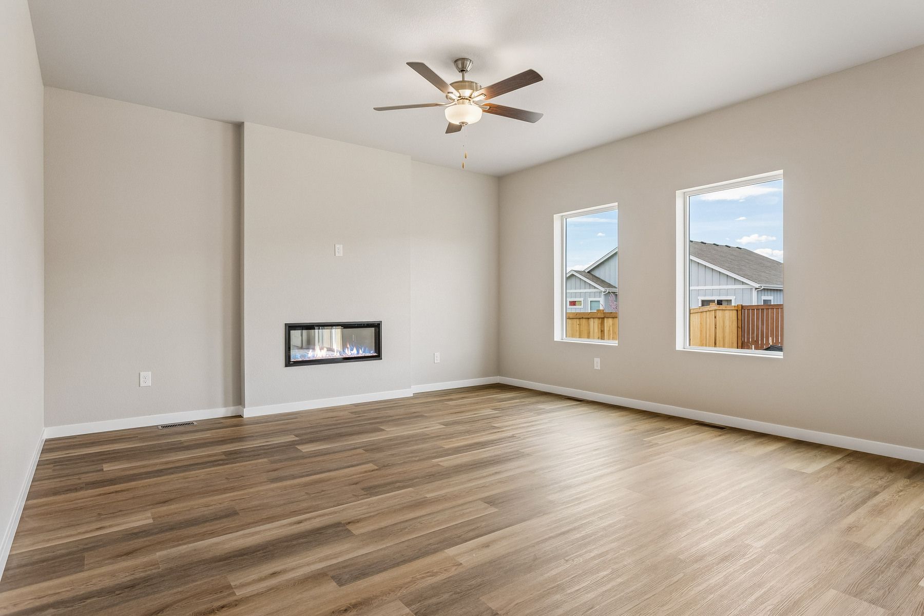 The family room is spacious with a ceiling fan and an electric fireplace.