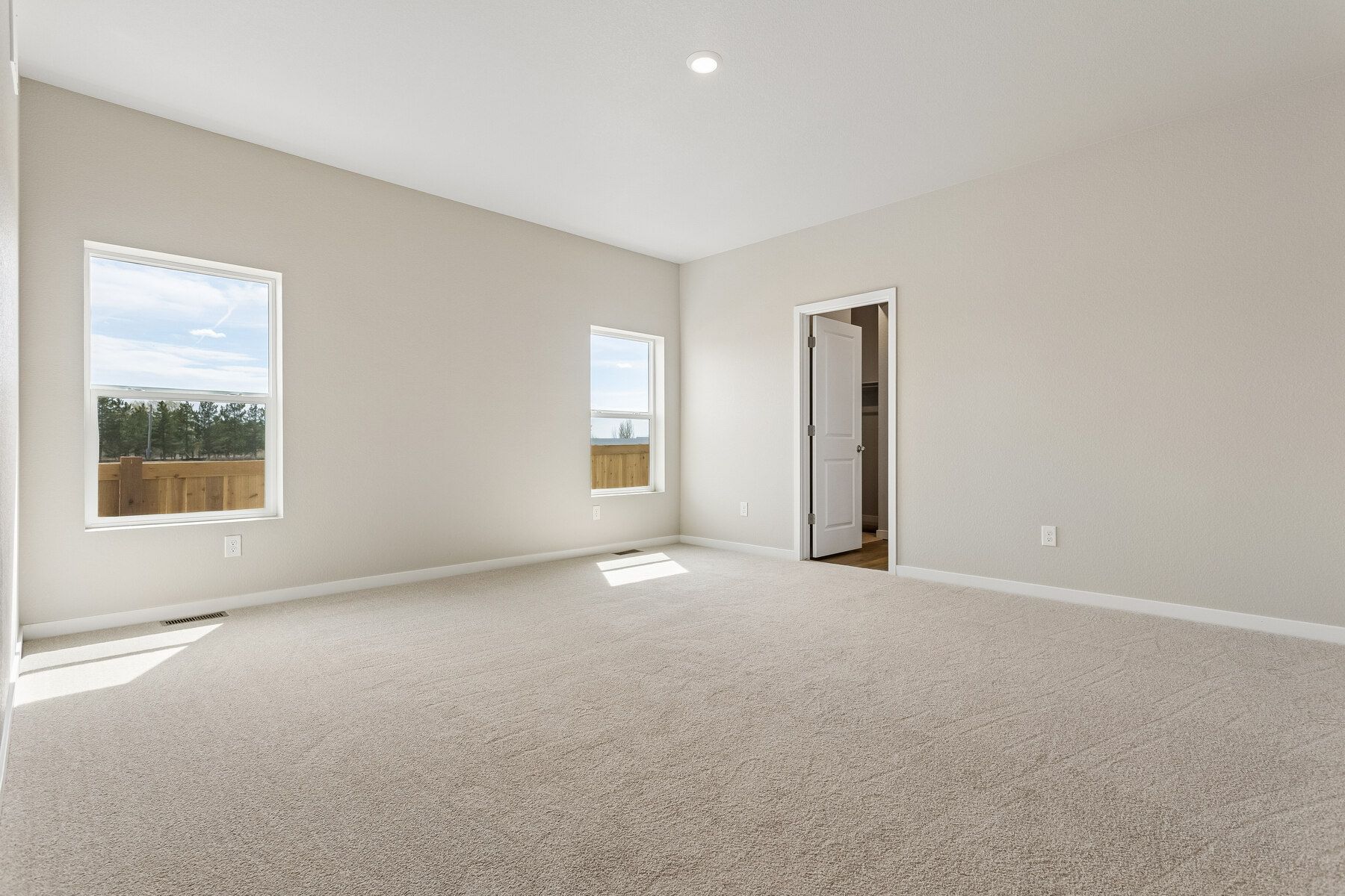 The master bedroom is spacious and has large windows.