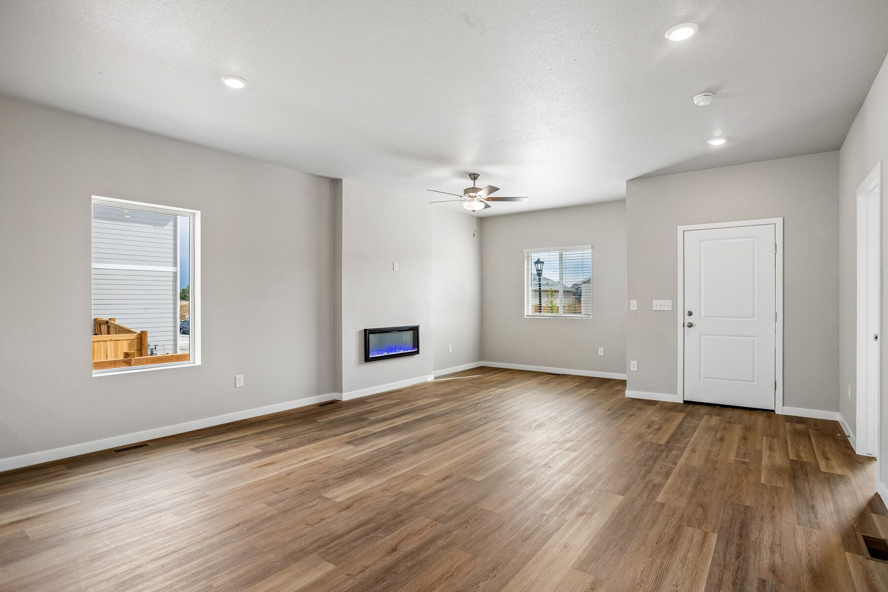 The family room is spacious with a ceiling fan and an electric fire place.