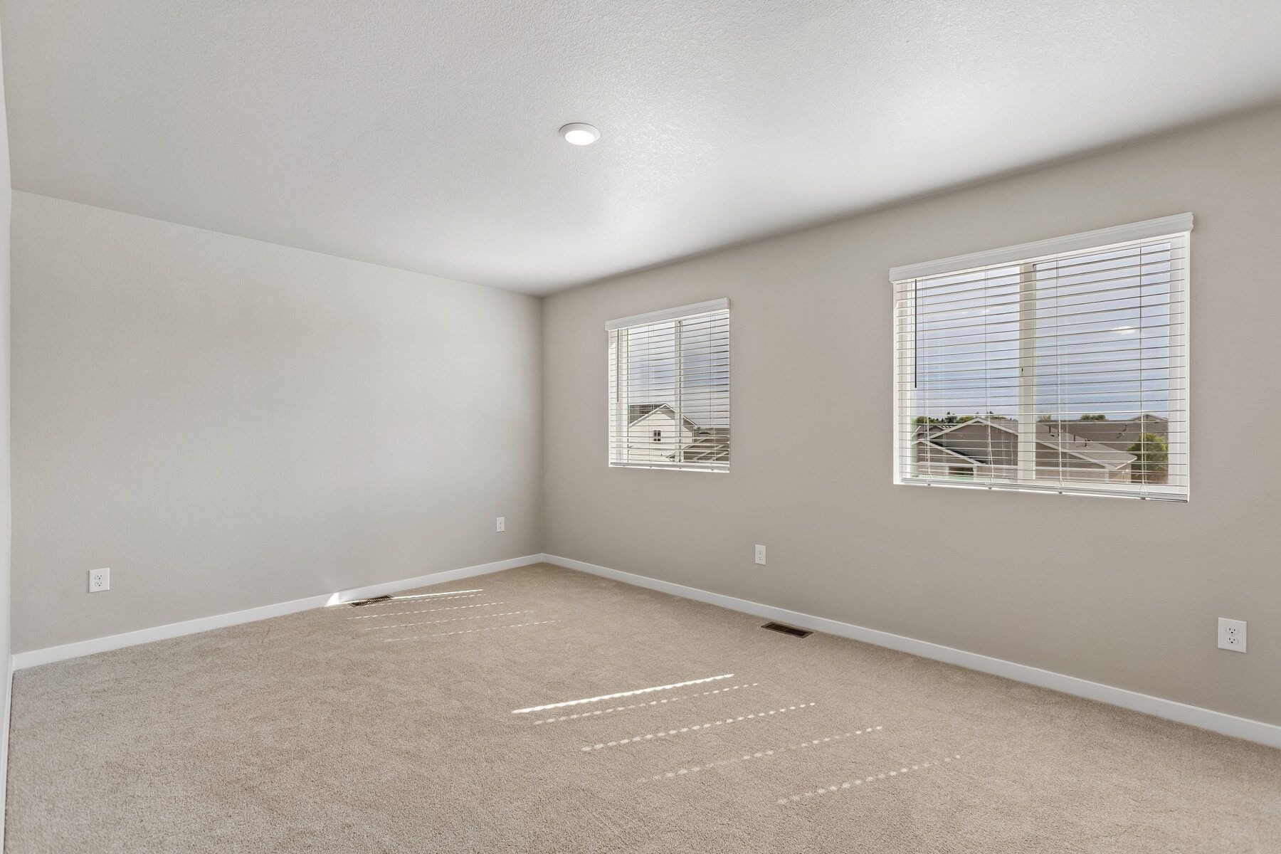 The master bedroom is spacious and has large windows.