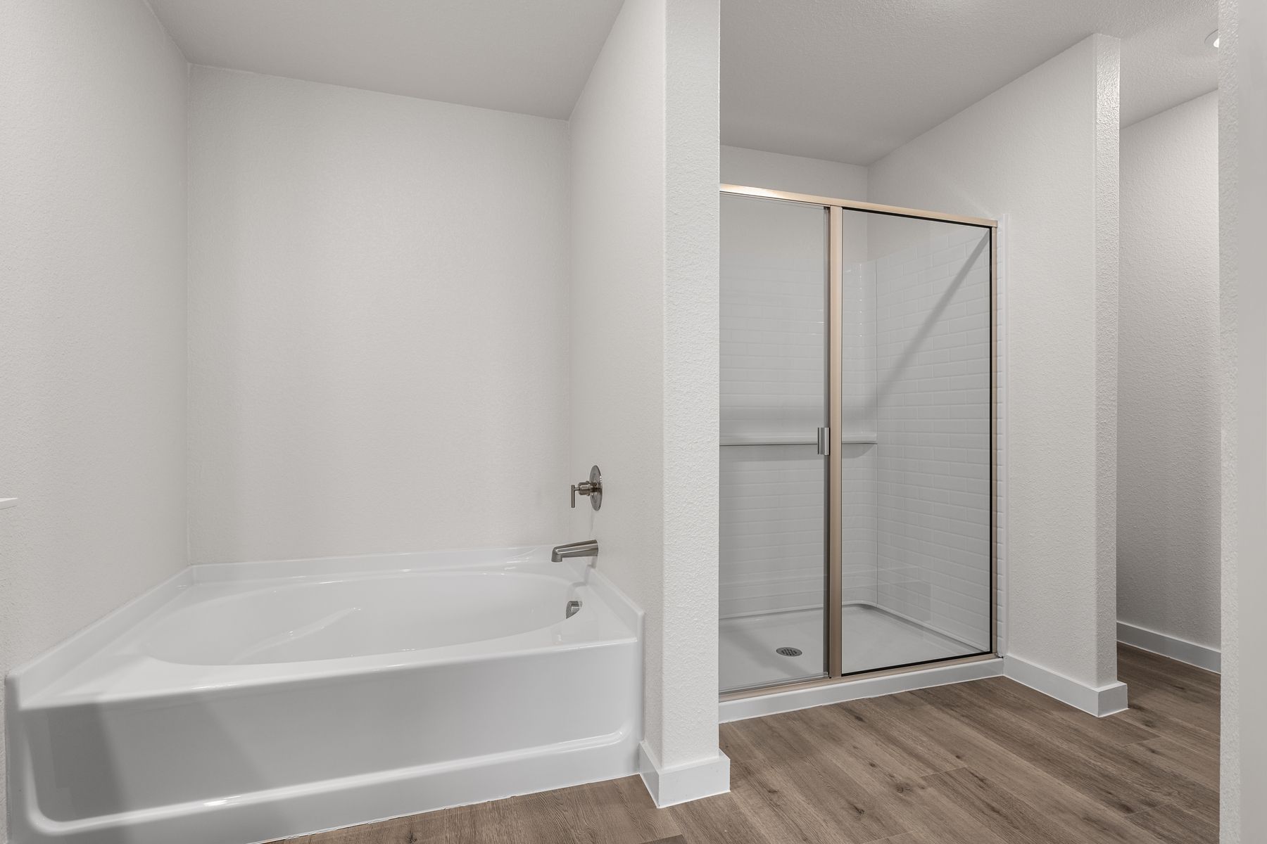 The master bathroom has a glass walk-in shower and garden tub.