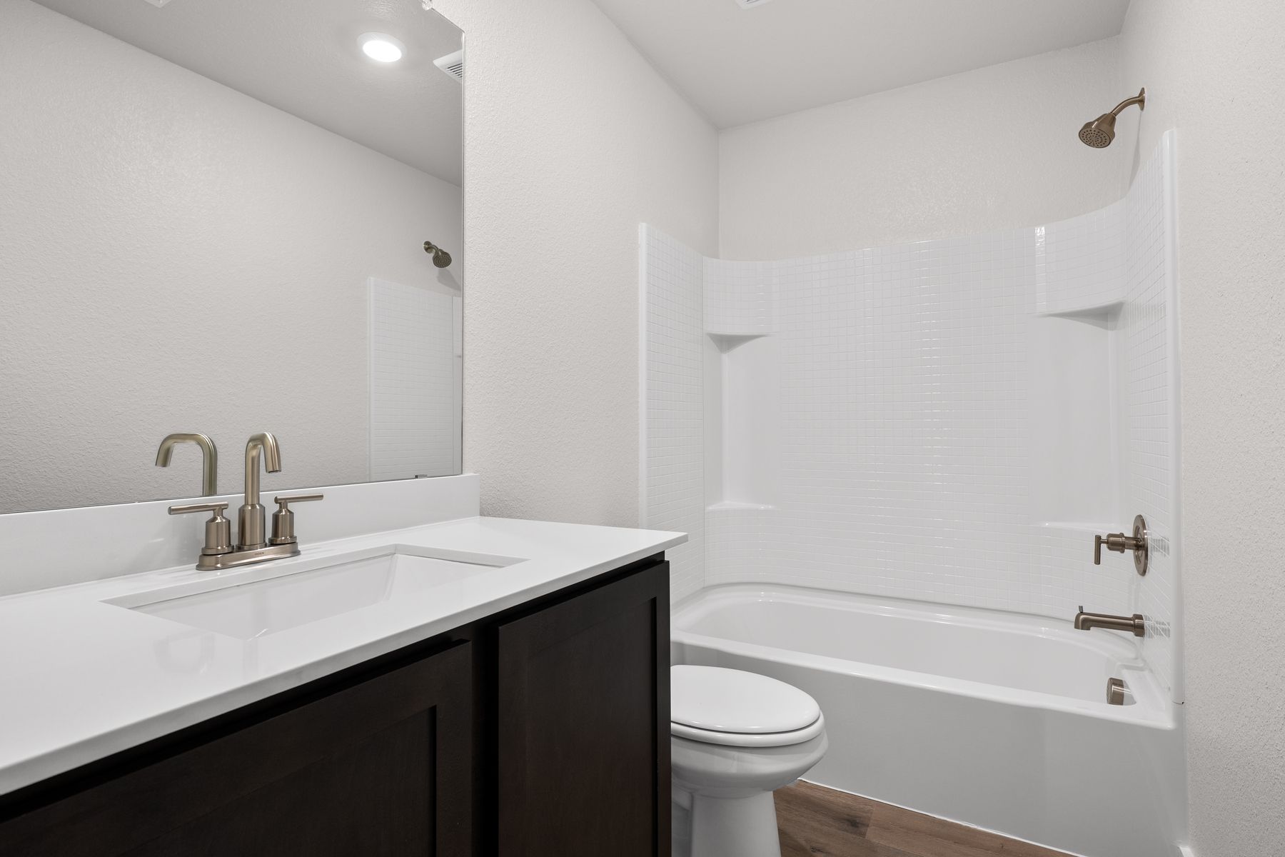 The secondary bathroom has a sprawling vanity and shower-tub combo.