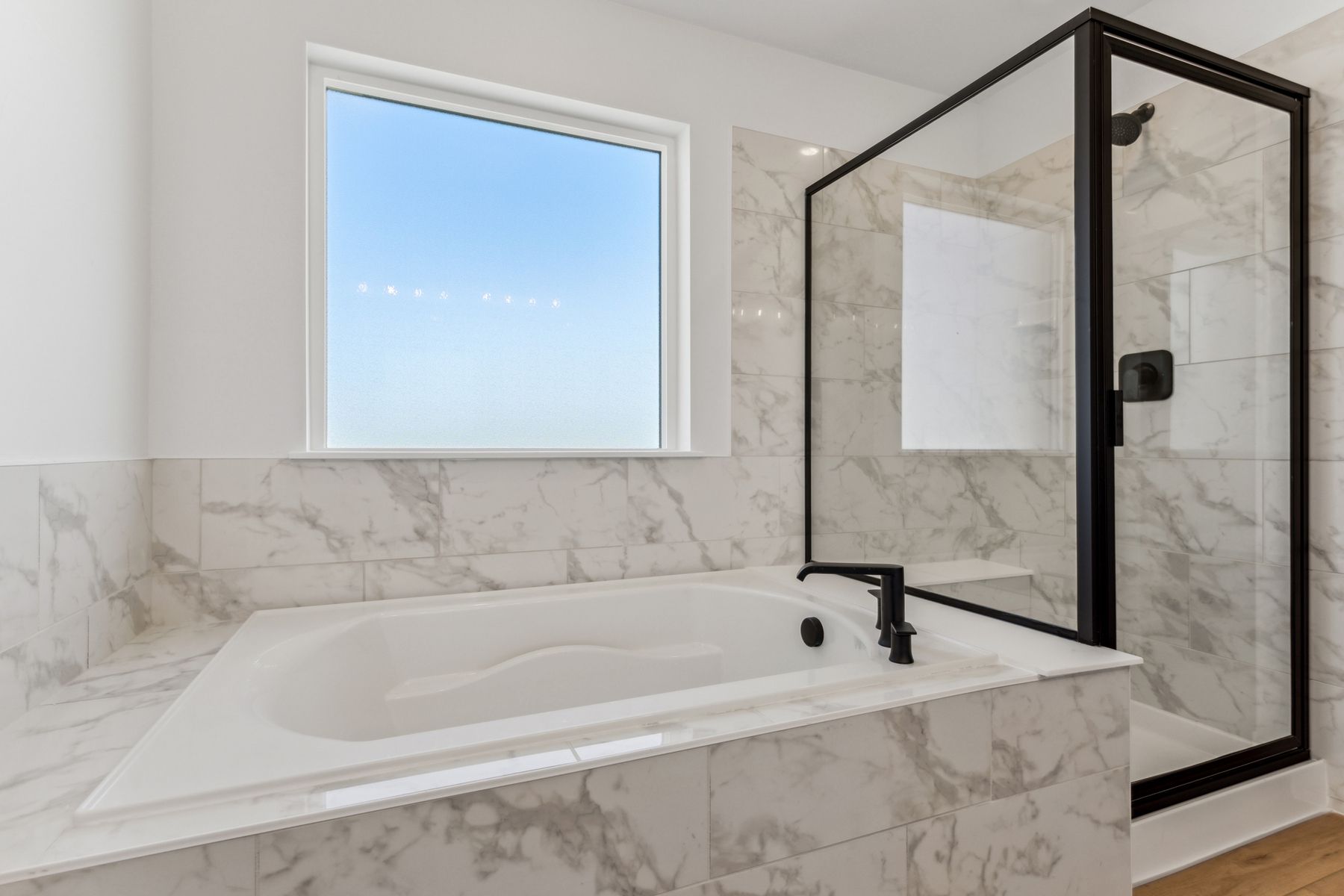 The master bathroom has a garden tub and a glass, walk-in shower.
