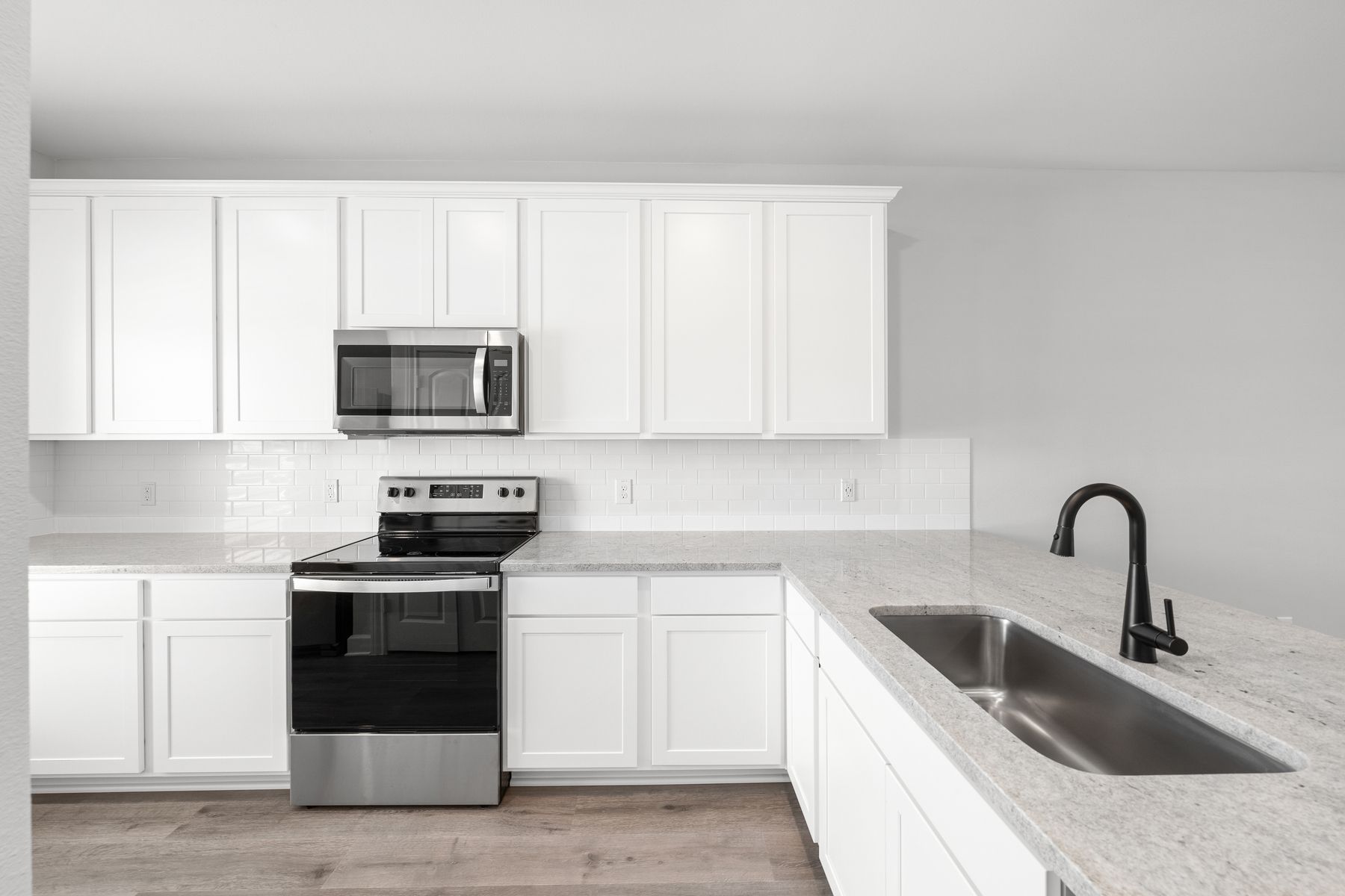 The kitchen has white cabinetry.
