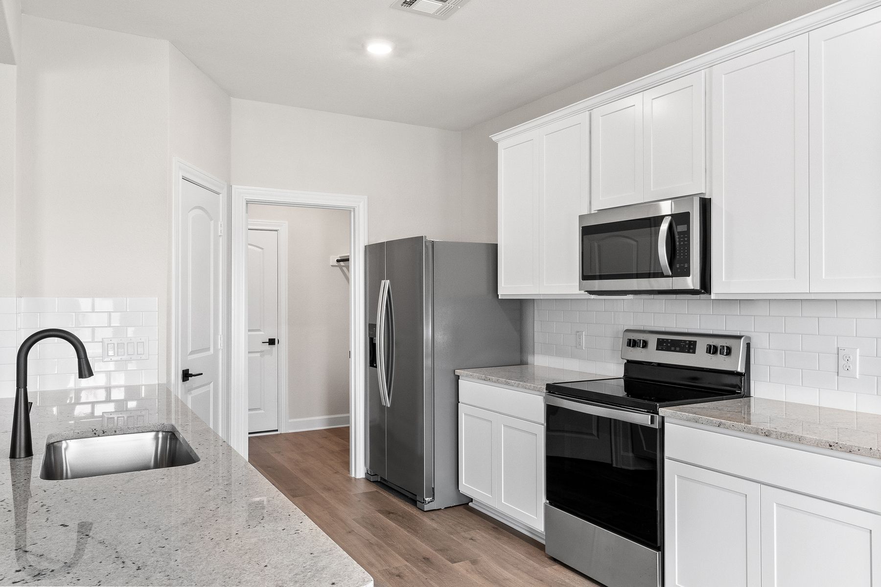The kitchen has white cabinetry.