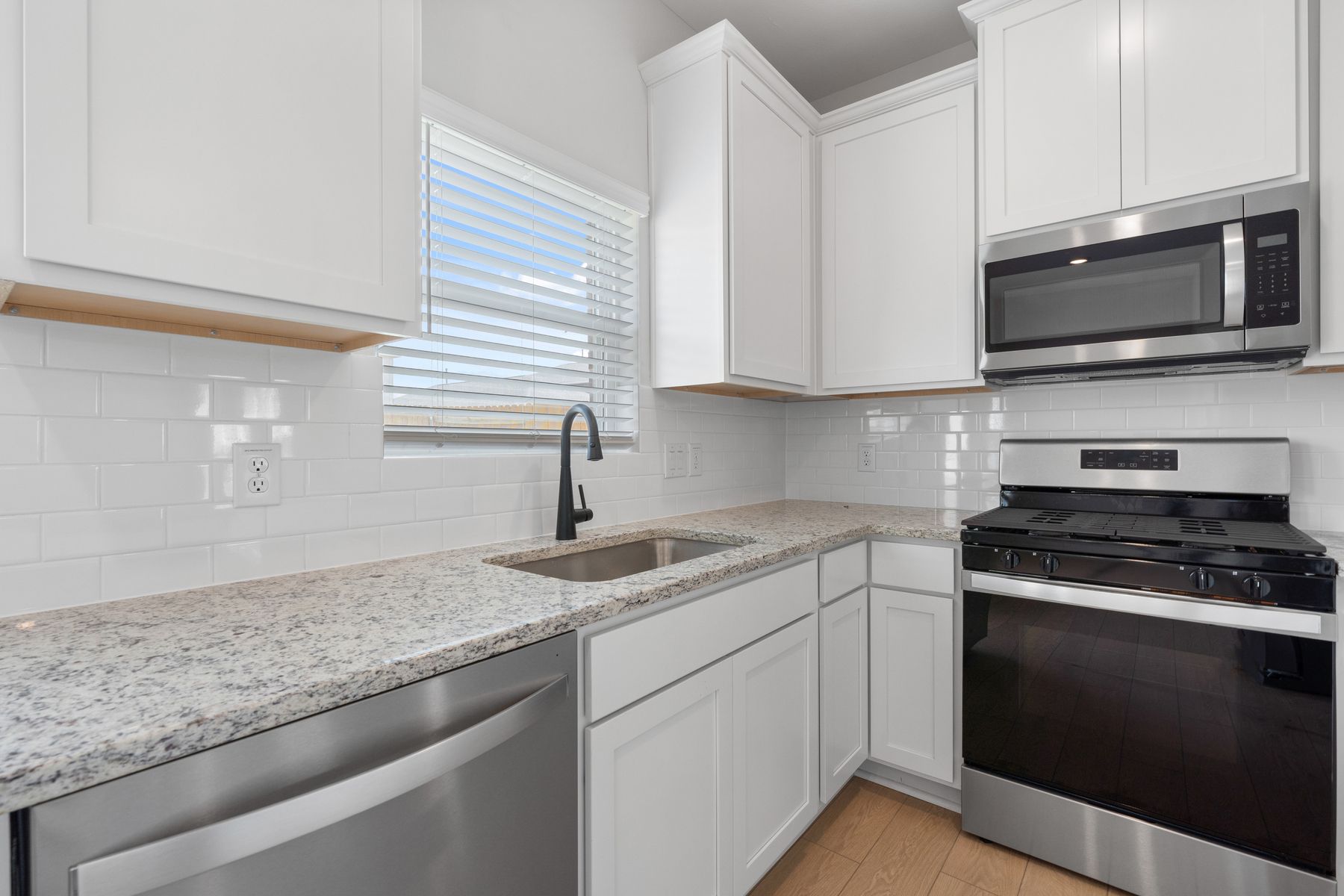 The kitchen has white cabinetry.