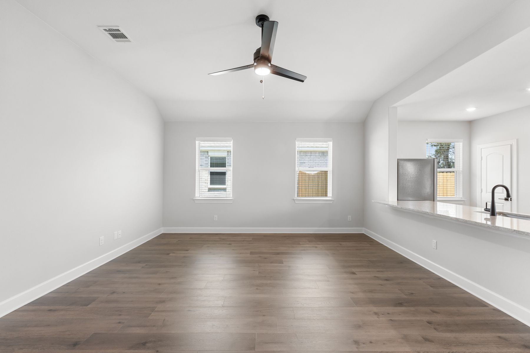 The fmaily room is spacious and has two large windows.