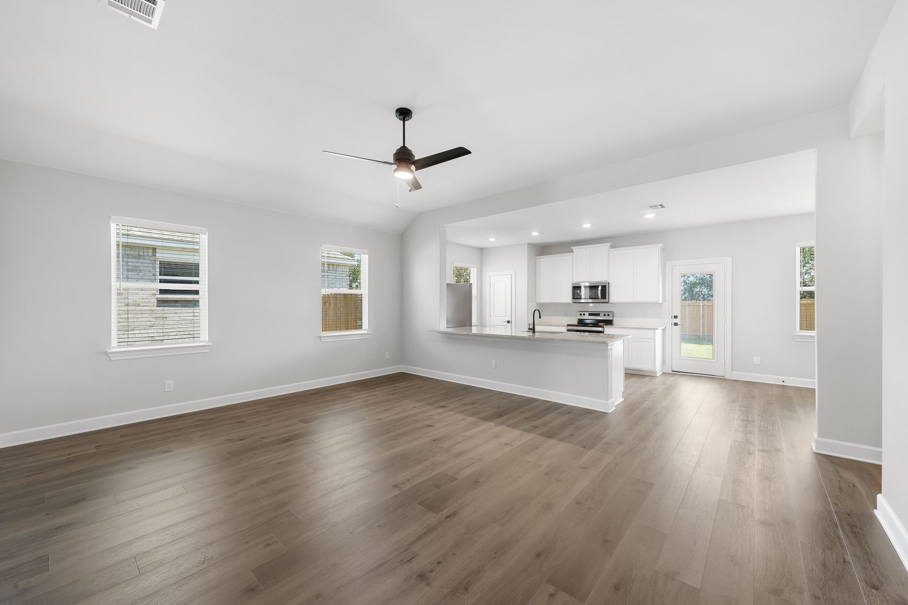 The kitchen has white wood cabinetry. 