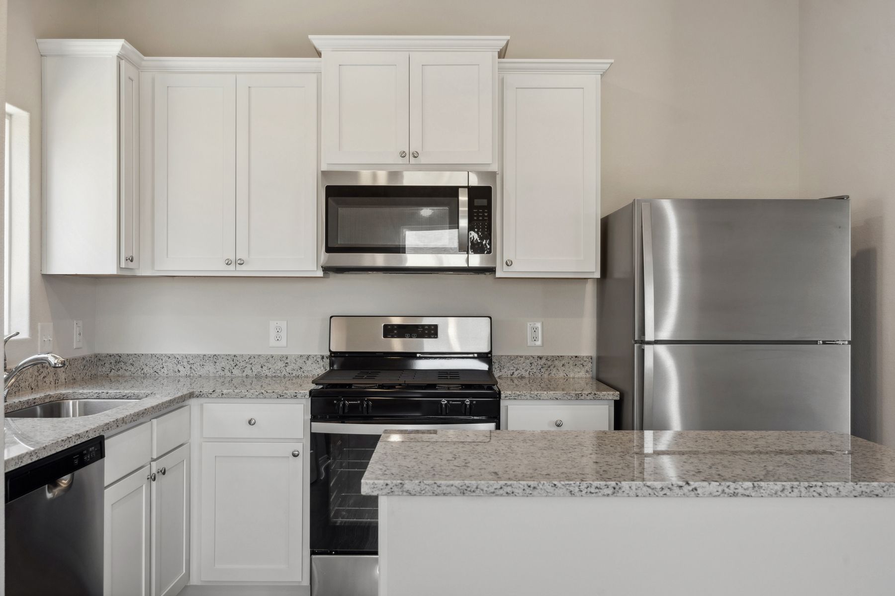 The kitchen has beautiful white cabinetry.