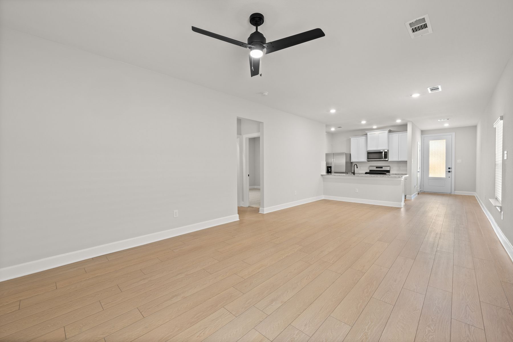 The kitchen, dining room, and living room are connected, creating an open-concept layout. 