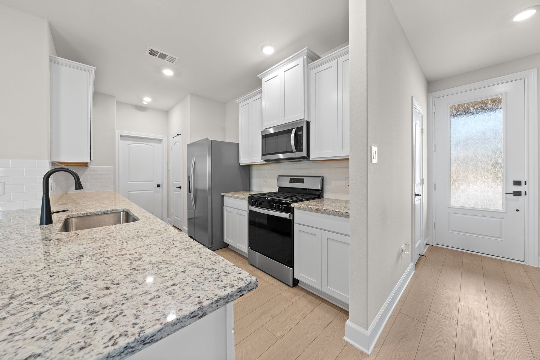 The kitchen has beautiful white cabinetry. 