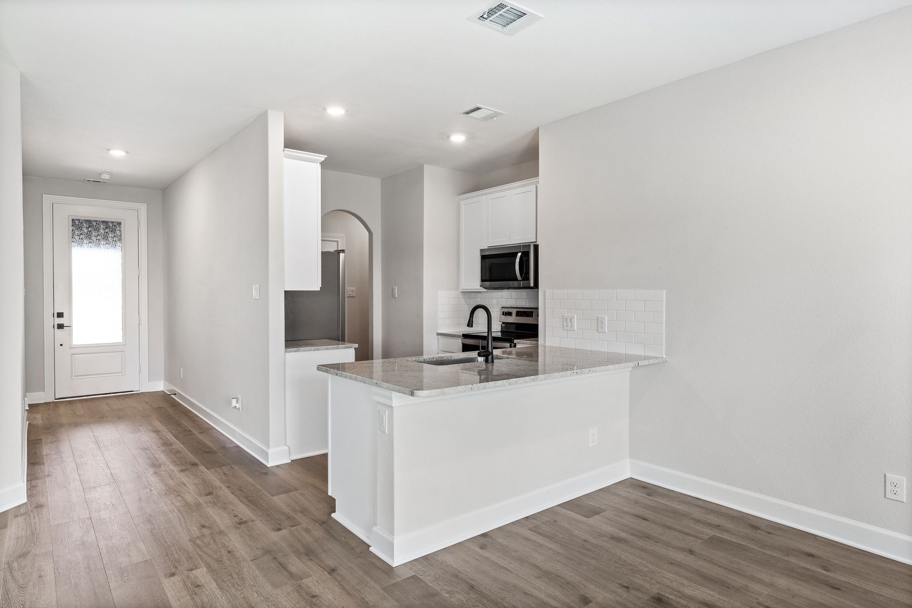 The kitchen has beautiful white cabinetry. 