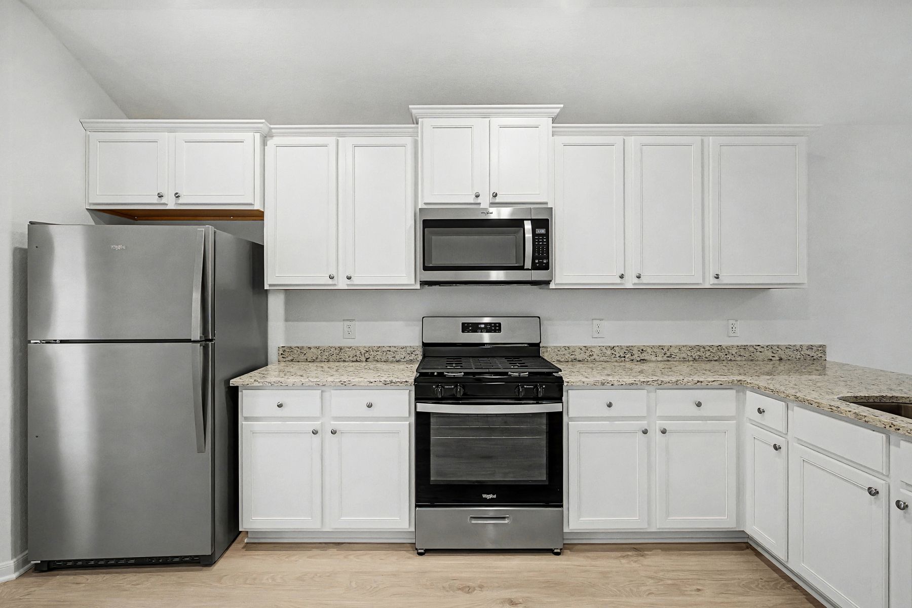 The kitchen has beauitful white wood cabinetry.