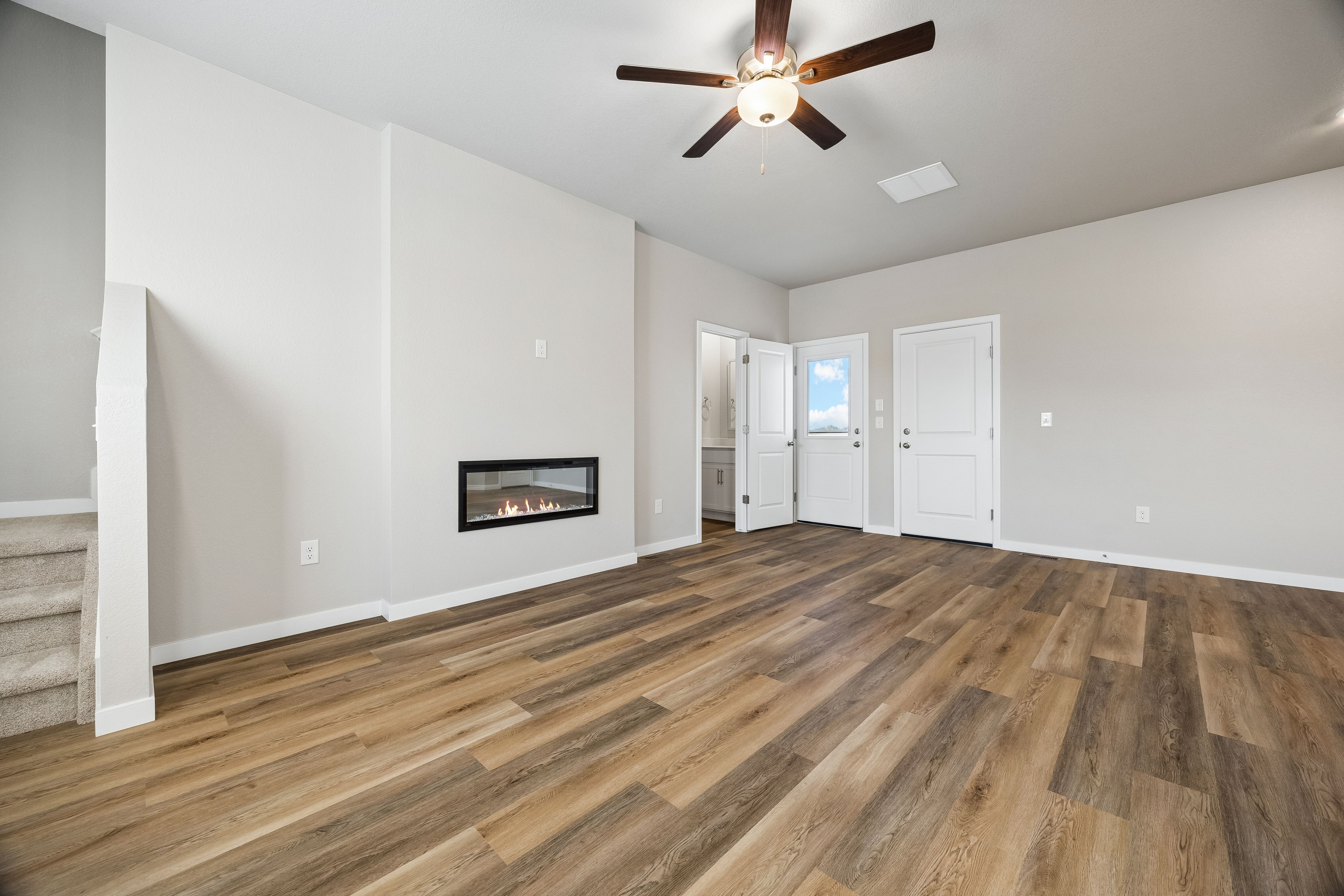 The family room is spacious with a ceiling fan and an electric fireplace.