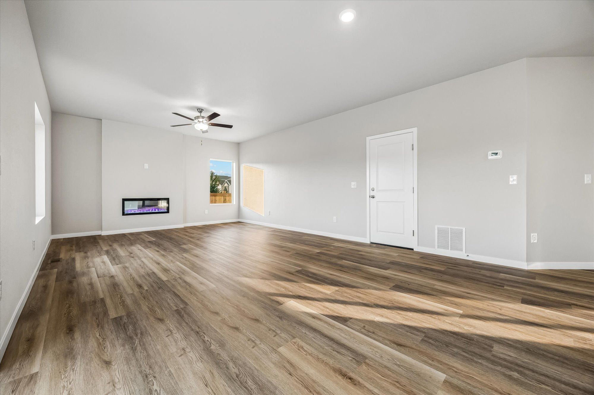 The family room is spacious with a ceiling fan and an electric fireplace.