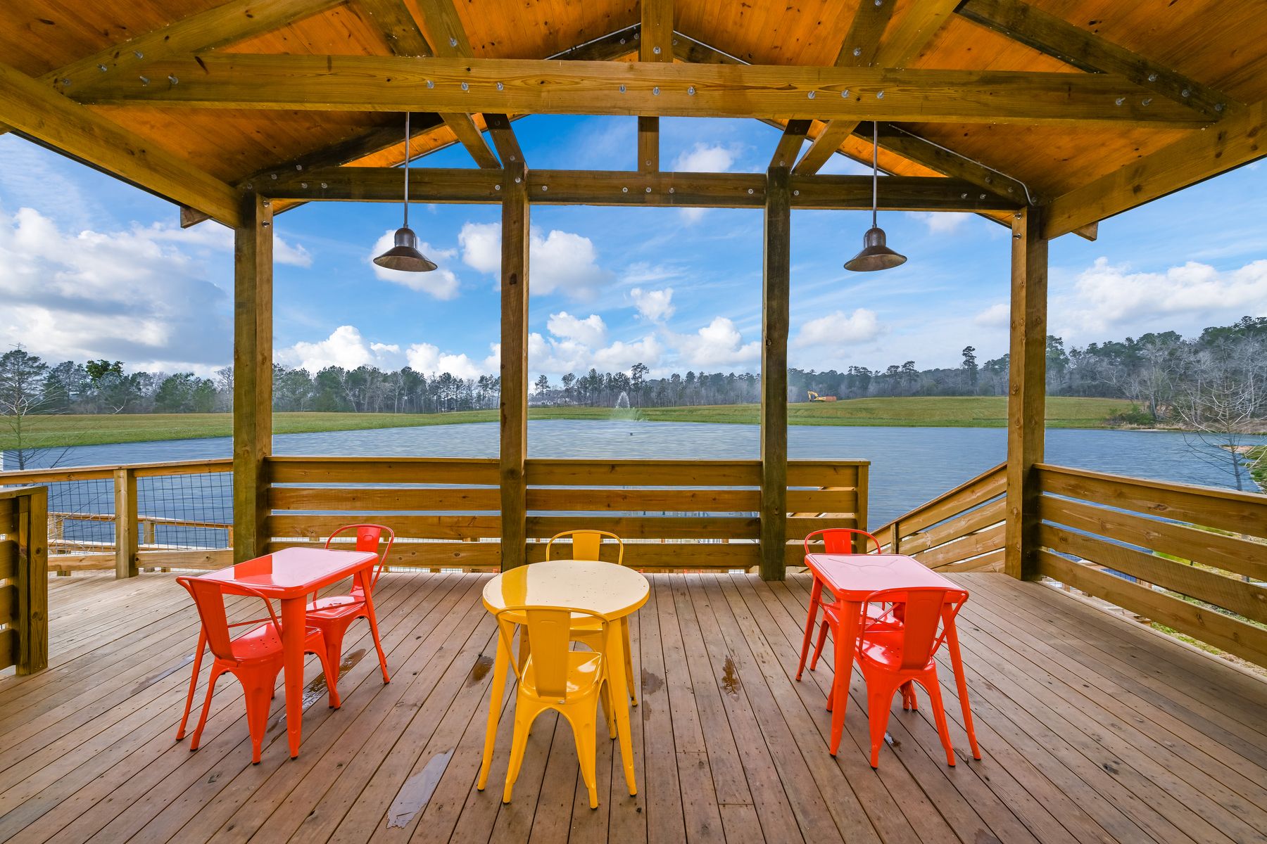 Cabin deck with seating and tables overlooking the lake and the fishing pier