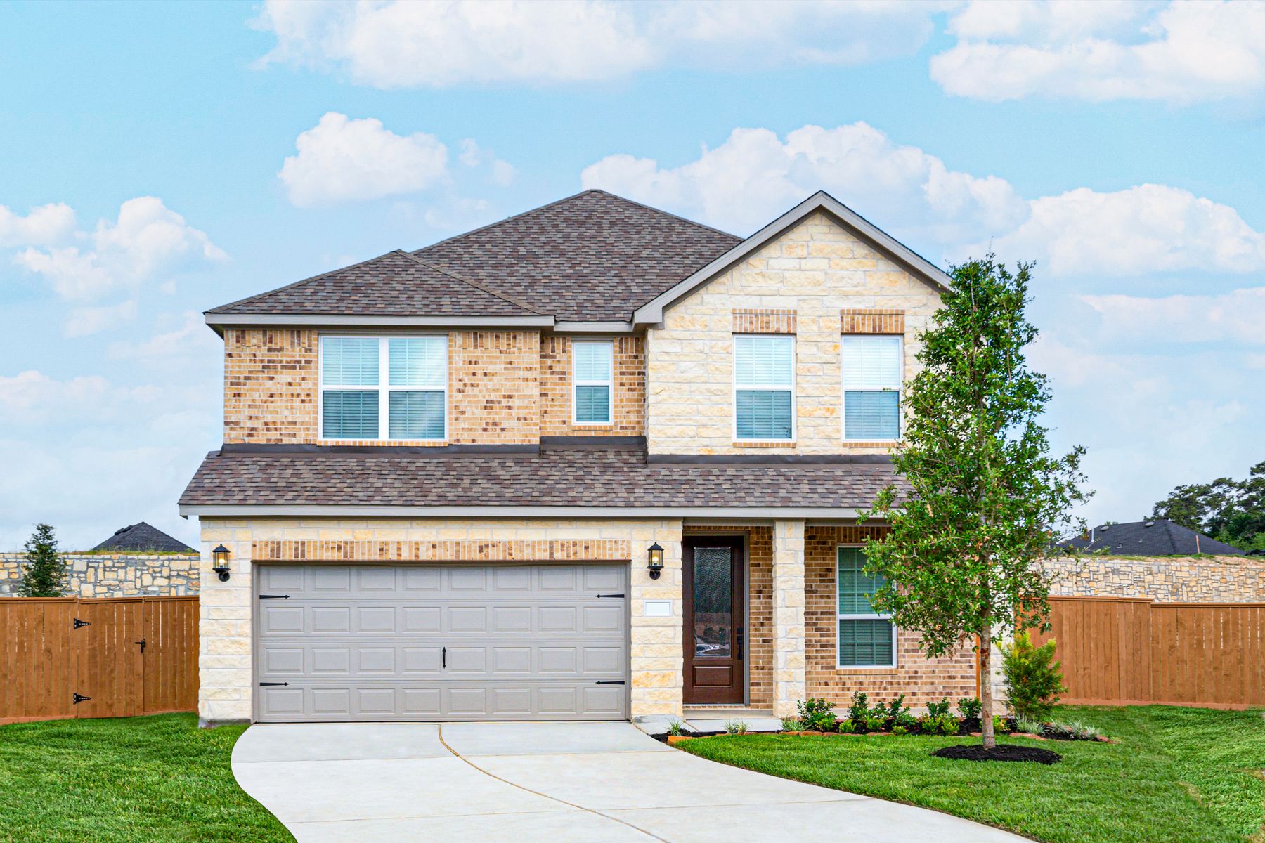 The Mangosteen plan, a two-story home with brick, stone and a covered patio