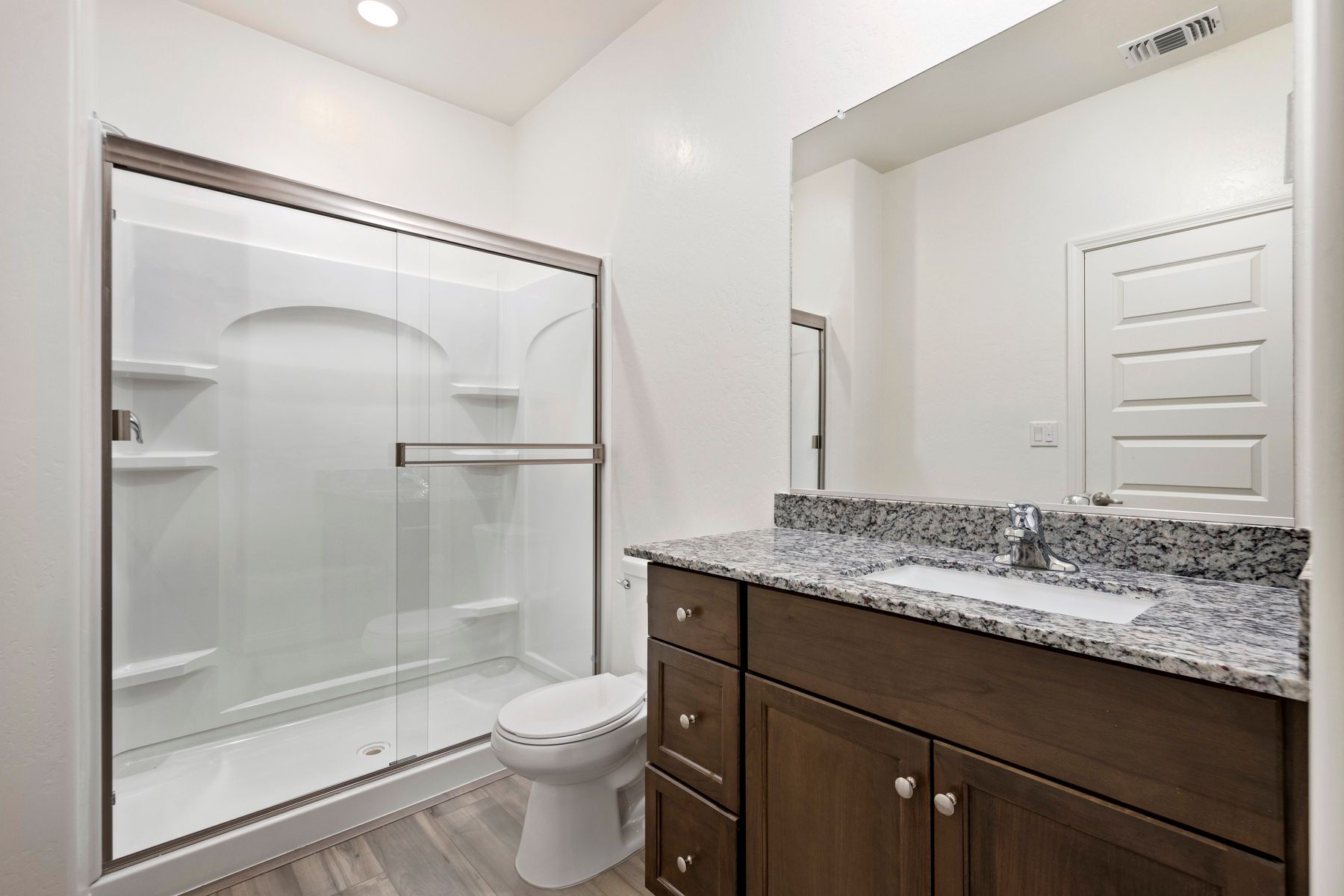 The master bathroom has a large vanity and a step in shower.