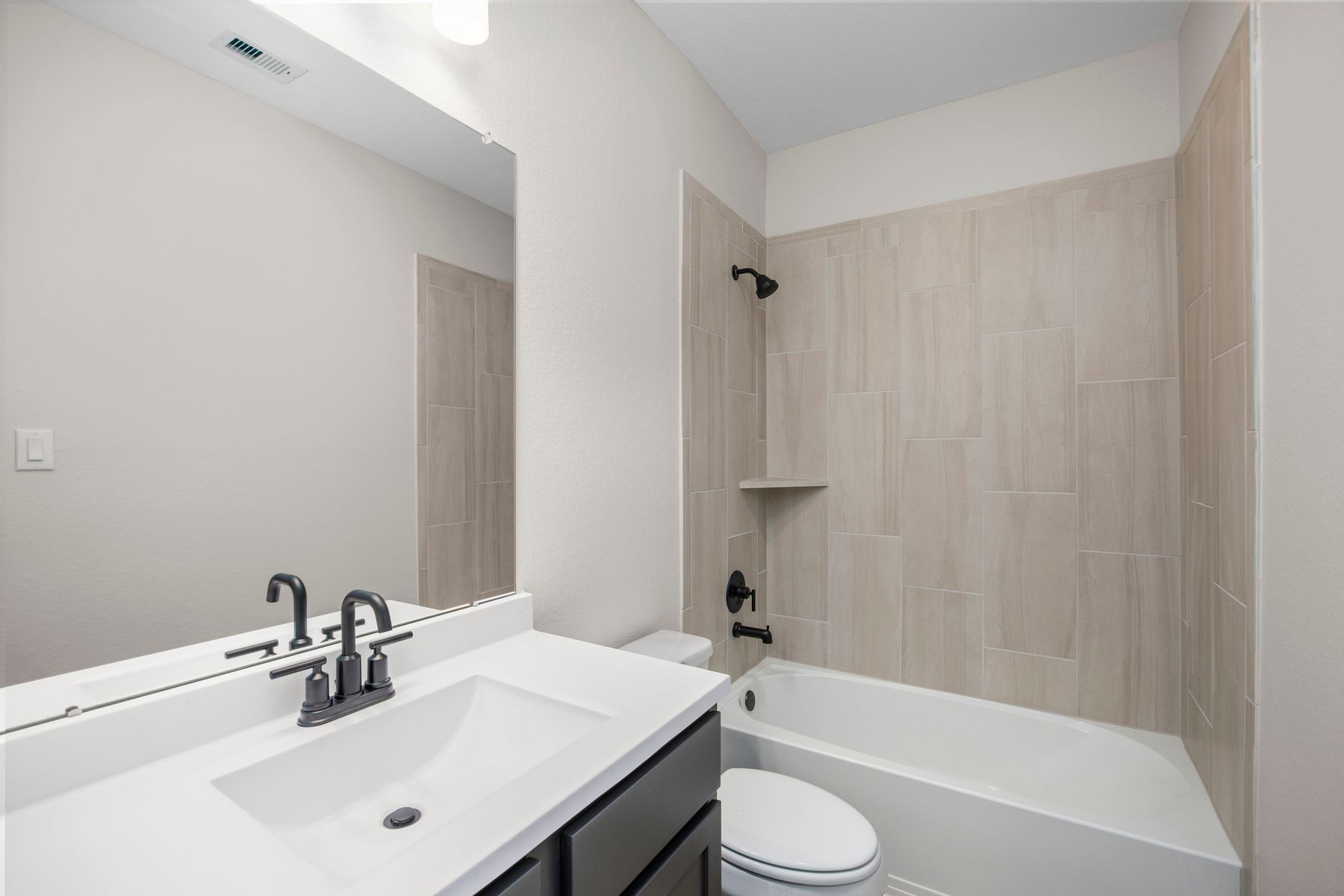 This secondary bathroom has a tub/shower combination. 