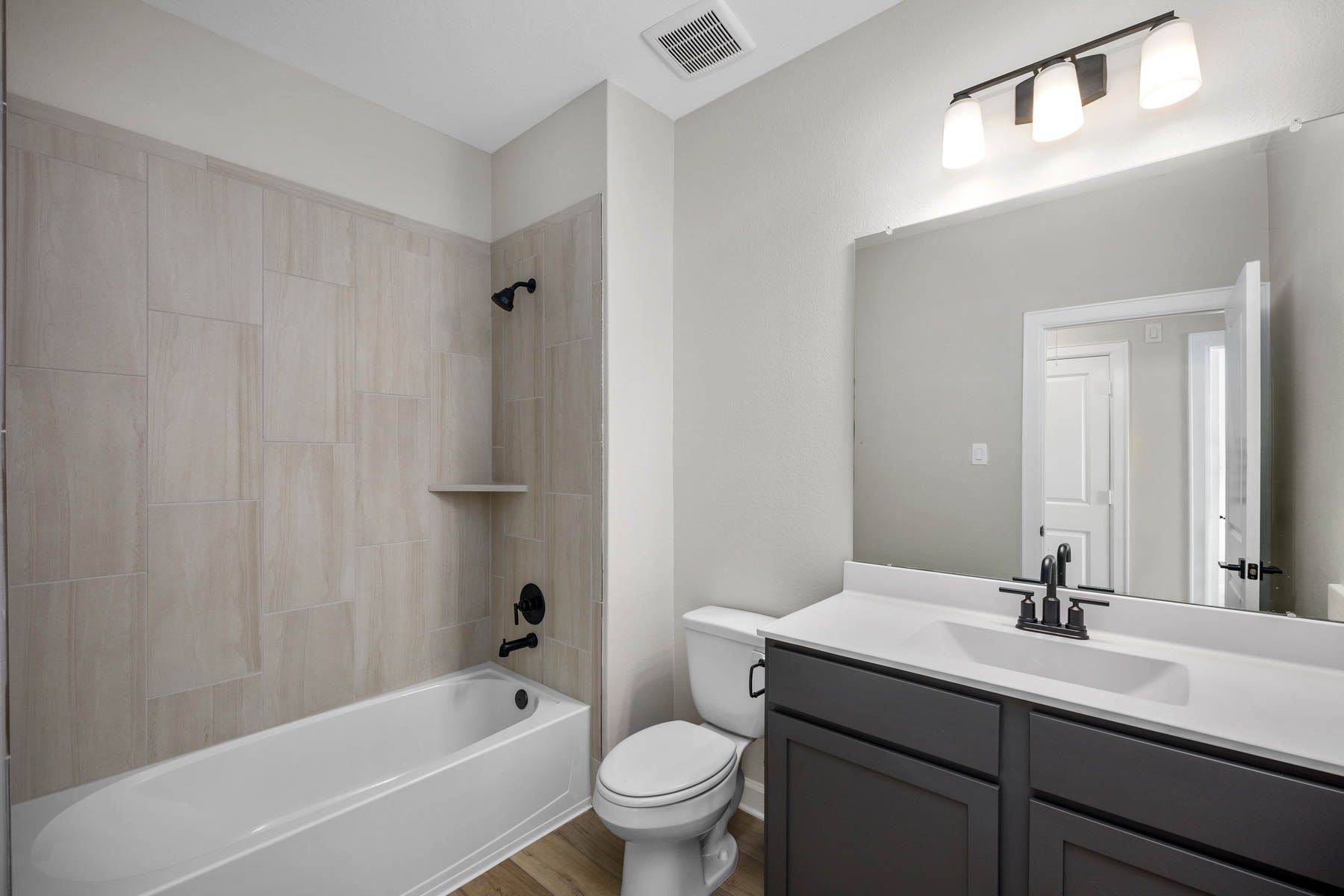 This secondary bathroom has a tub/shower combination. 
