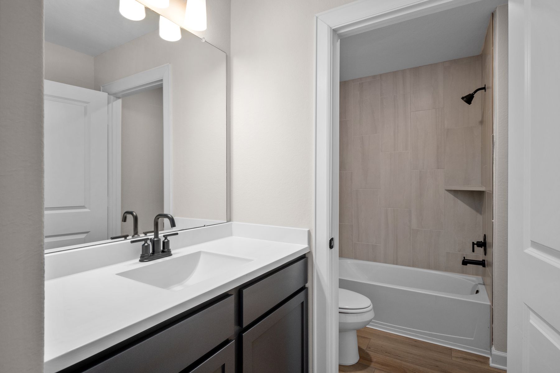 This secondary bathroom has a tub/shower combination. 