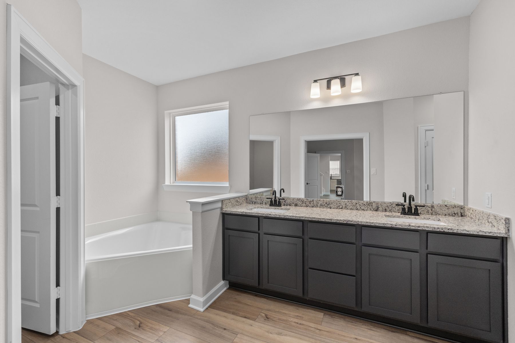 The master bathroom has a dual sink vanity and a soaking tub.