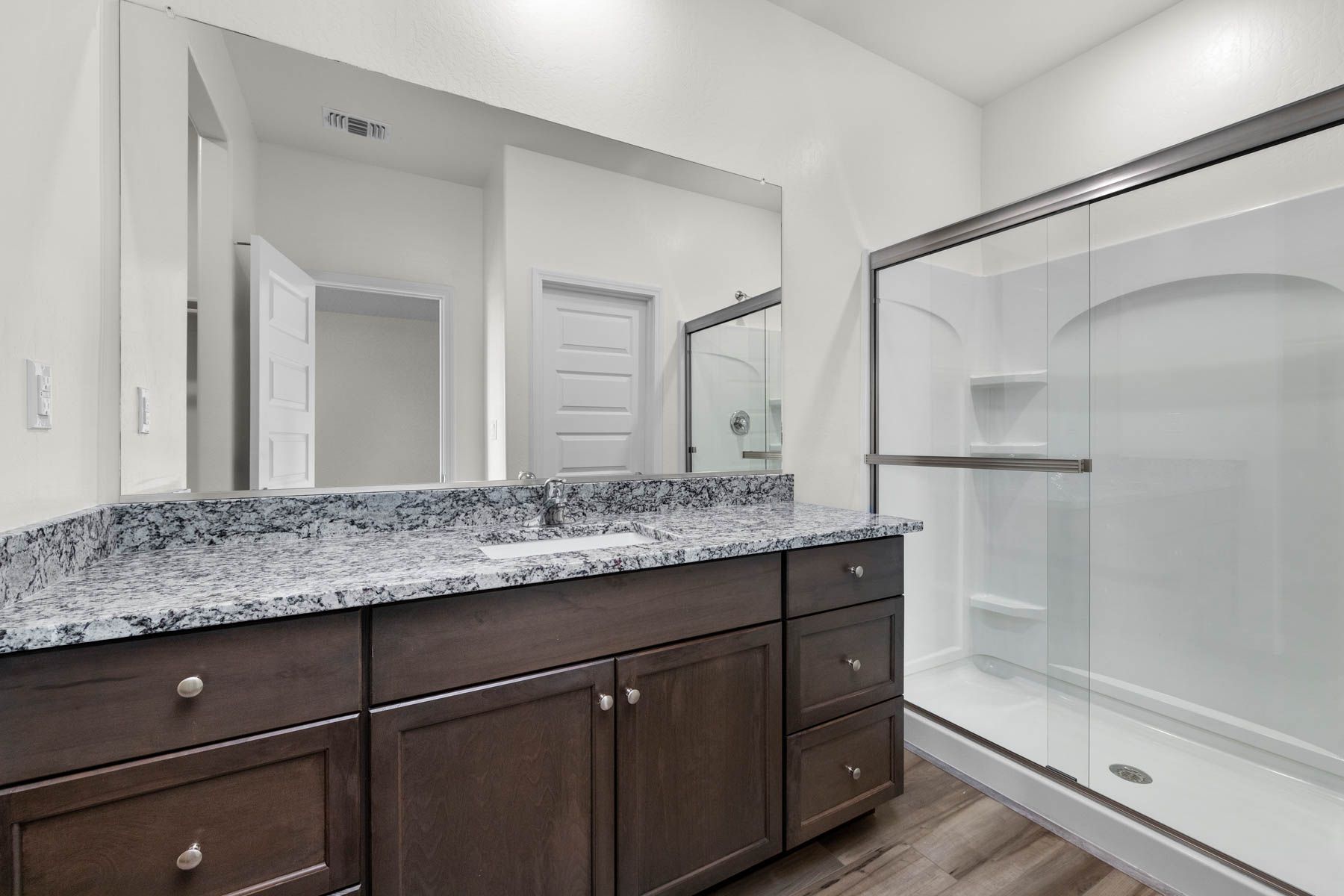 The master bathroom has a large vanity and a step in shower.