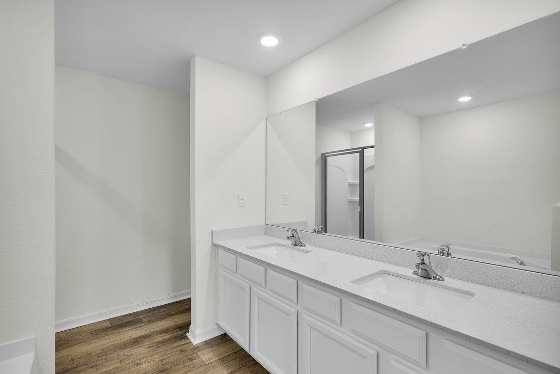The master bathroom has a spacious two sink vanity, linen closet, walk-in shower, and a tub