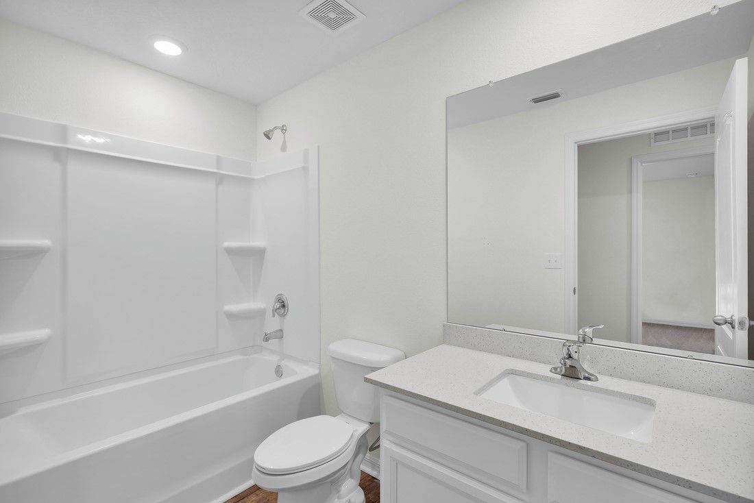 The extra bathroom has a spacious vanity with a tub