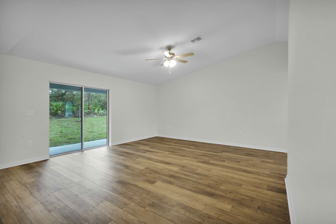 The family room of the Brickell has a sliding glass door that leads out into the backyard