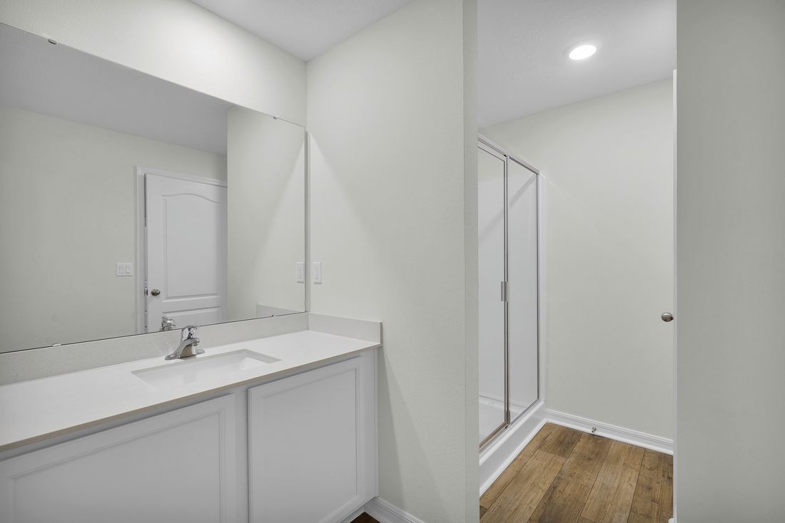 The master bathroom has a large vanity with a walk in shower and large closet
